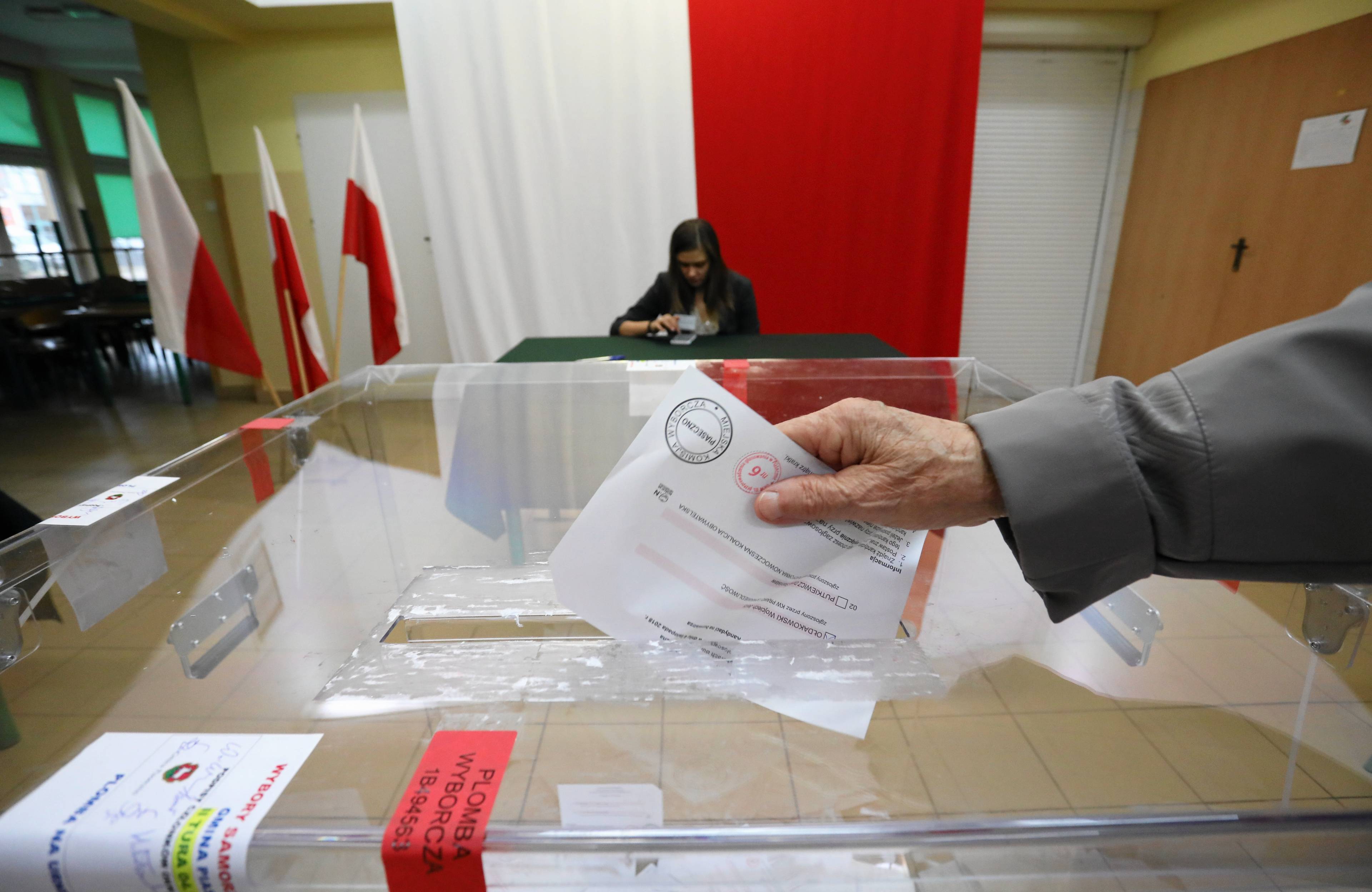 urna wyborcza i ręka wrzucająca głos