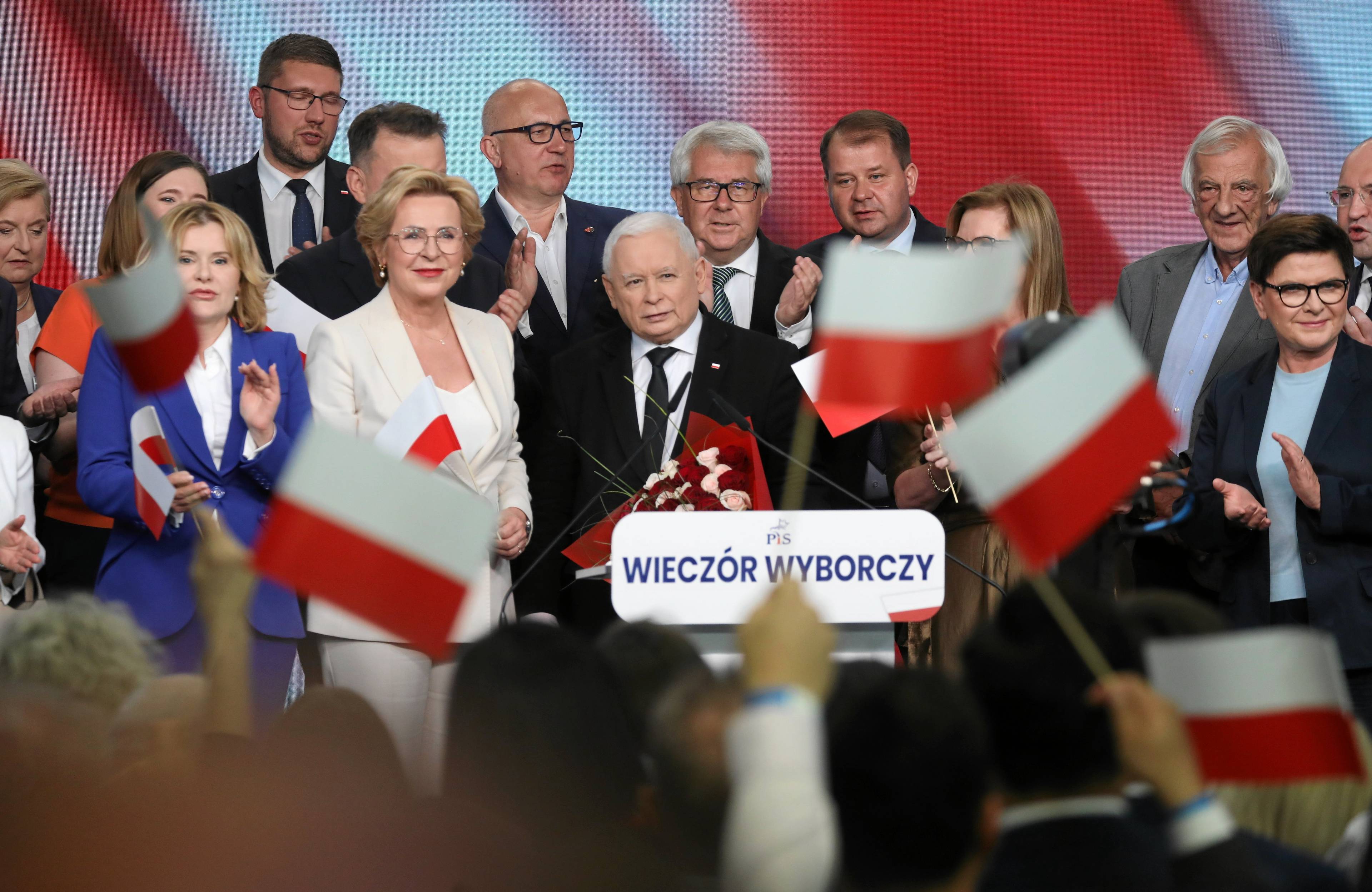 Najważniejsi politycy PiS na scenie w trakcie wieczoru wyborczego, na pierwszym planie za mikrofonem Jarosław Kaczyński