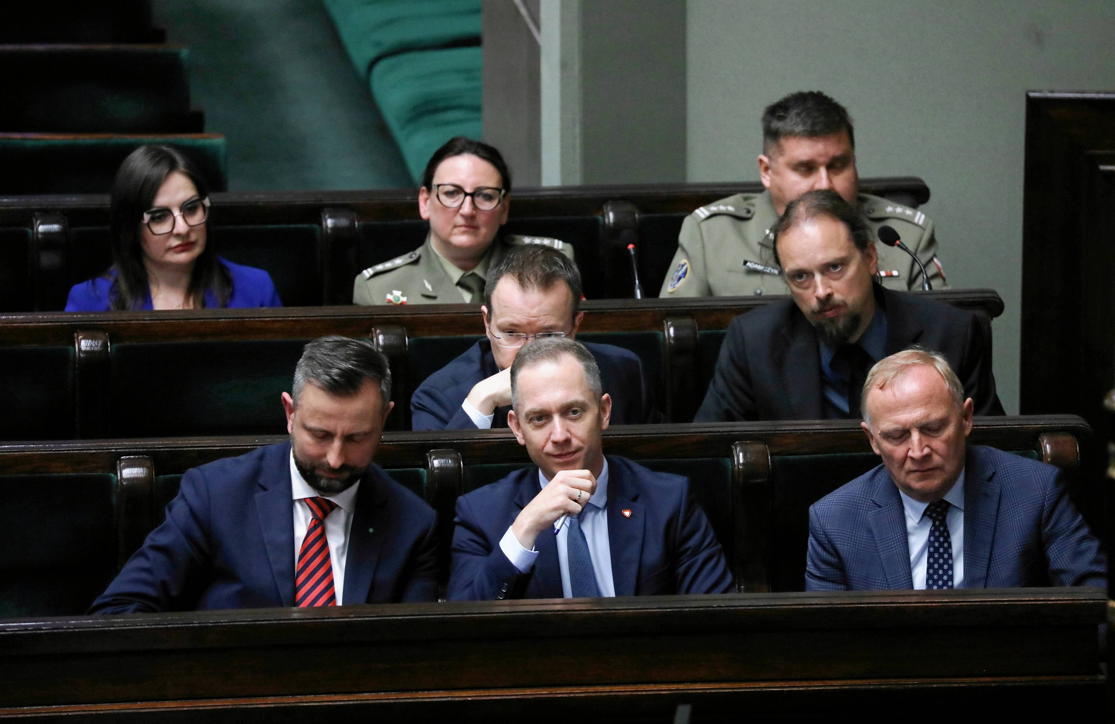 Kilklu mężczyzn w ławach rządowych w Sejmie