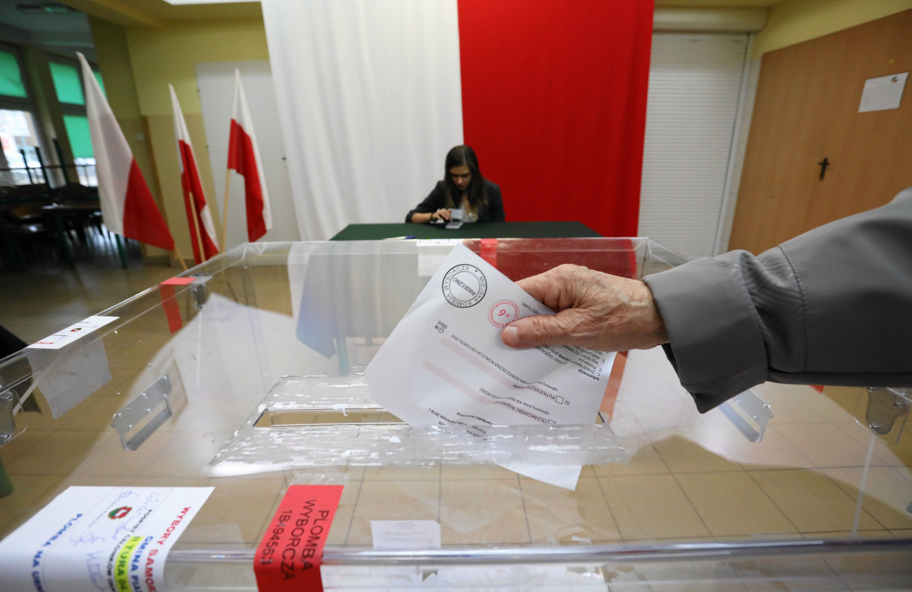 urna wyborcza i ręka wrzucająca głos