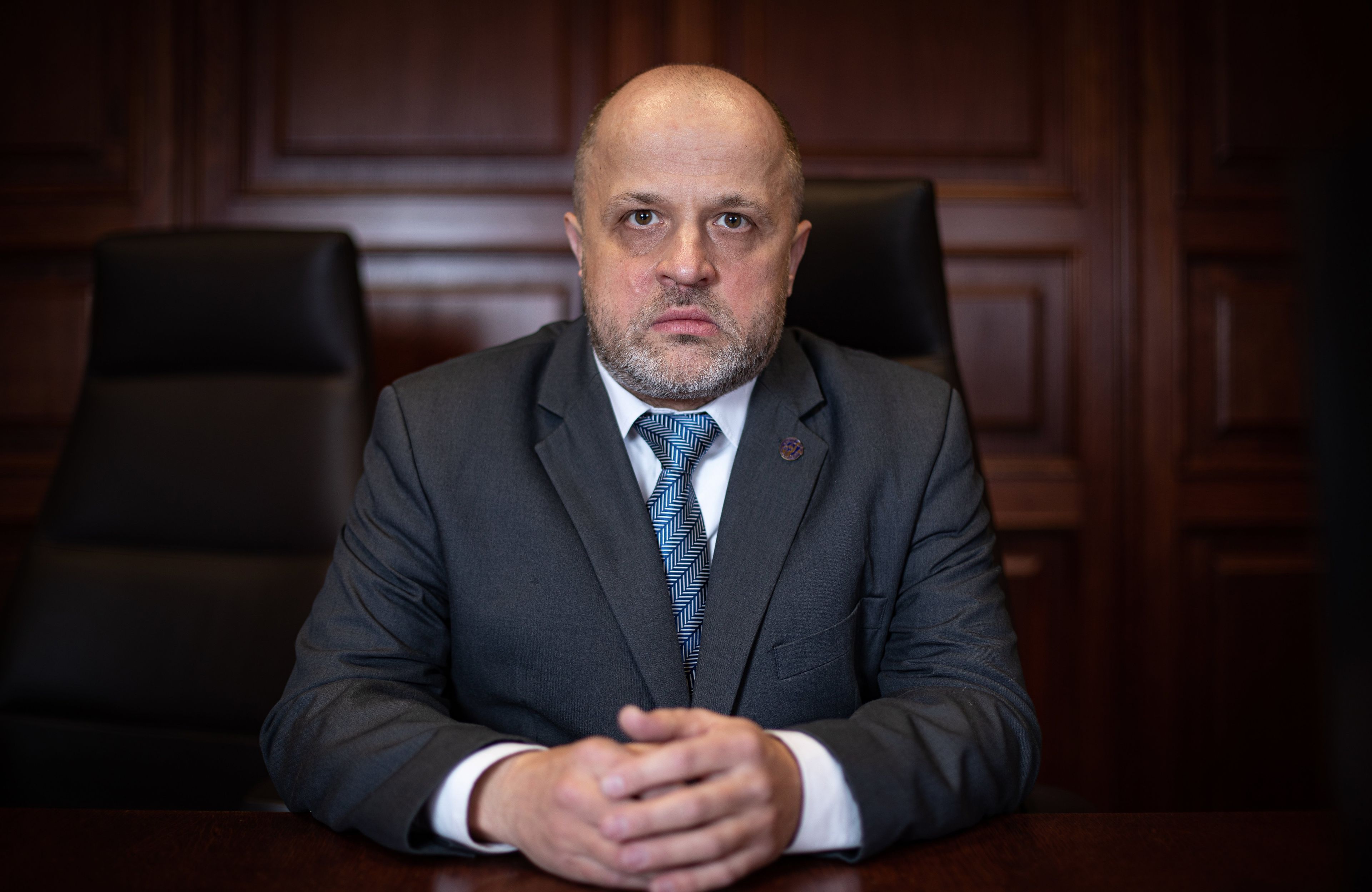 Piotr Gąciarek: mężczyzna w ciemnym garniturze i niebieskim krawacie