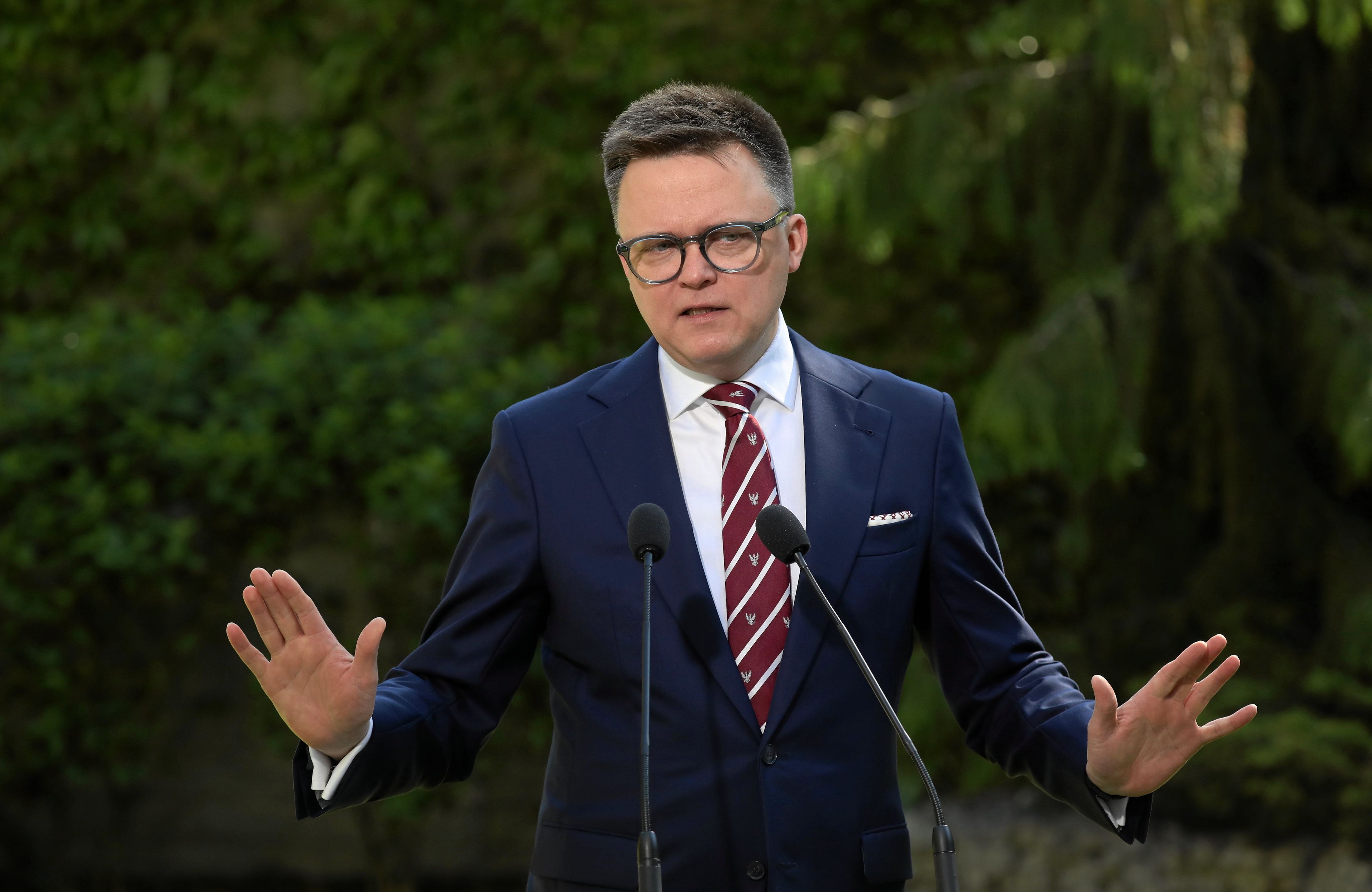 Szymon Hołownia z uspokajającym gestem rąk