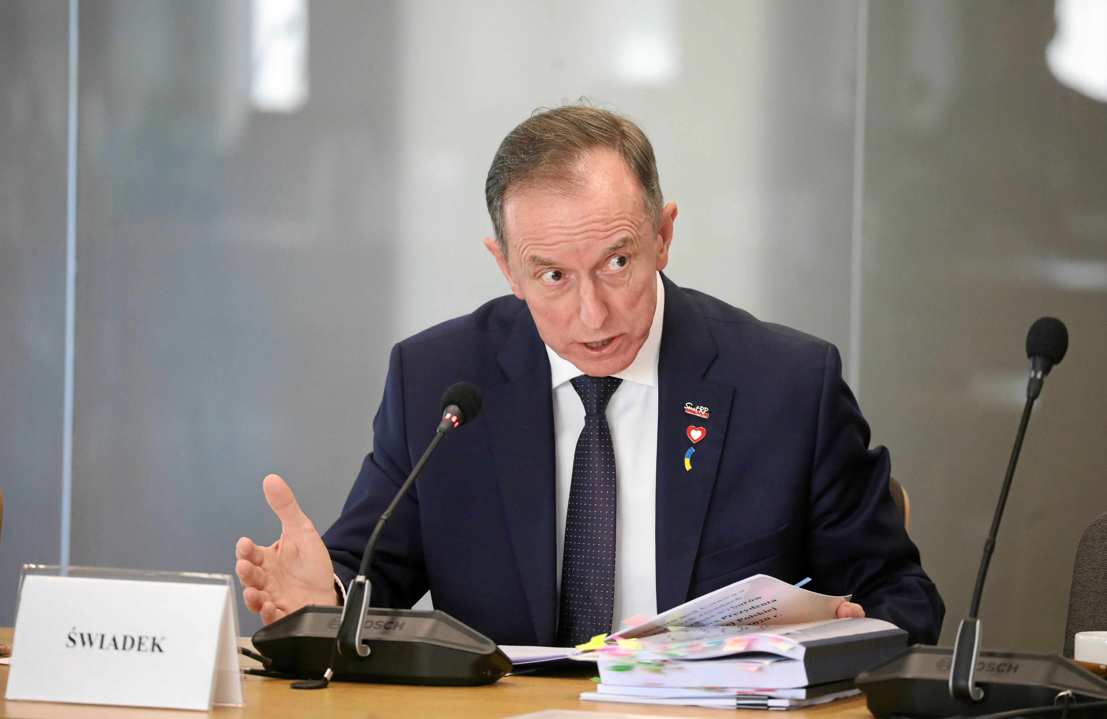 Mężczyzna na stanowisku dla świadka i stos dokumentów