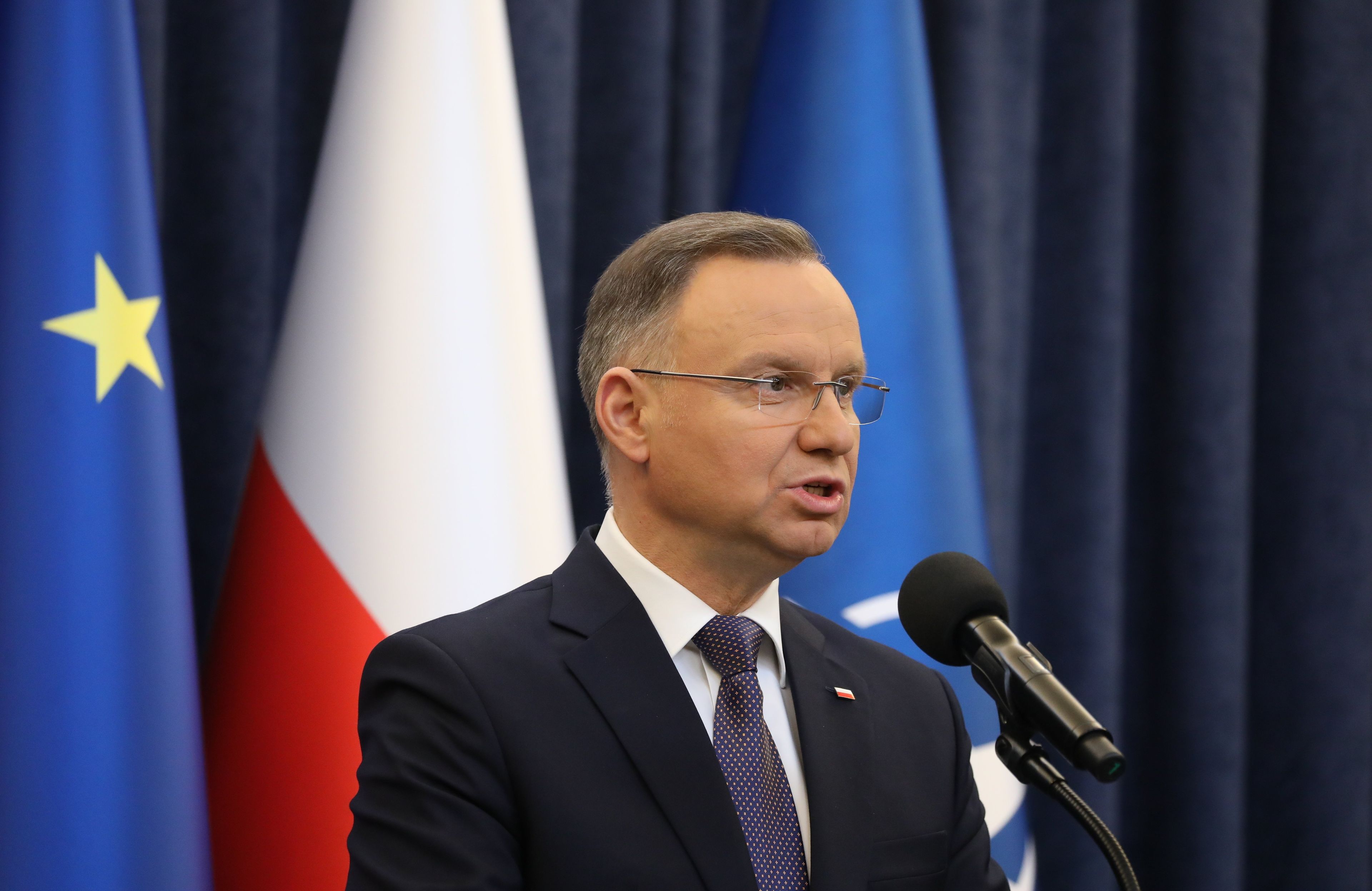 Andrzej Duda na tle flagi unijnej (niebieska z gwiazdką) i biało-czerwonej polskiej