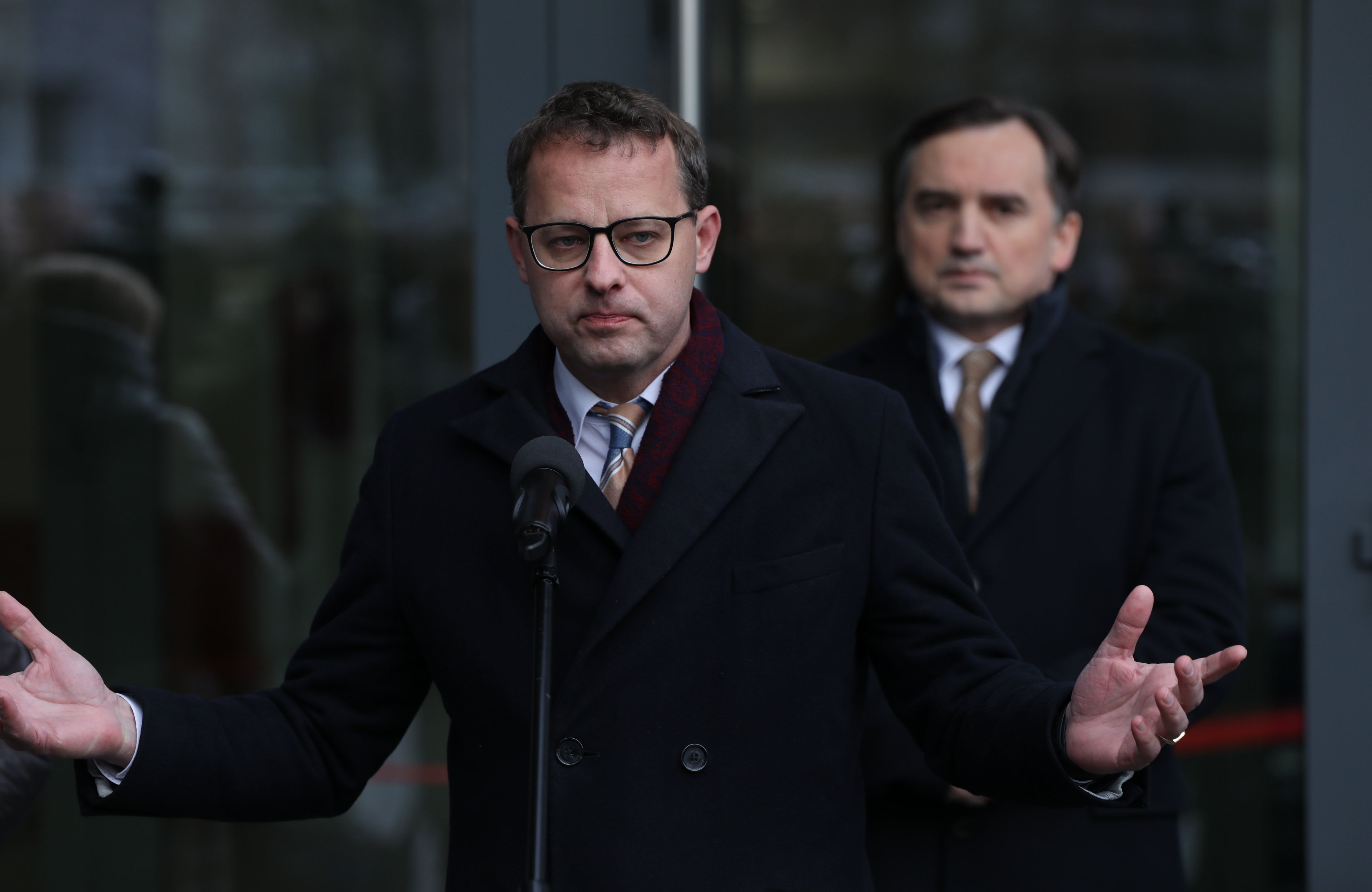 Marcin Romanowski rozkłada ręce, za nim Zbigniew Ziobro