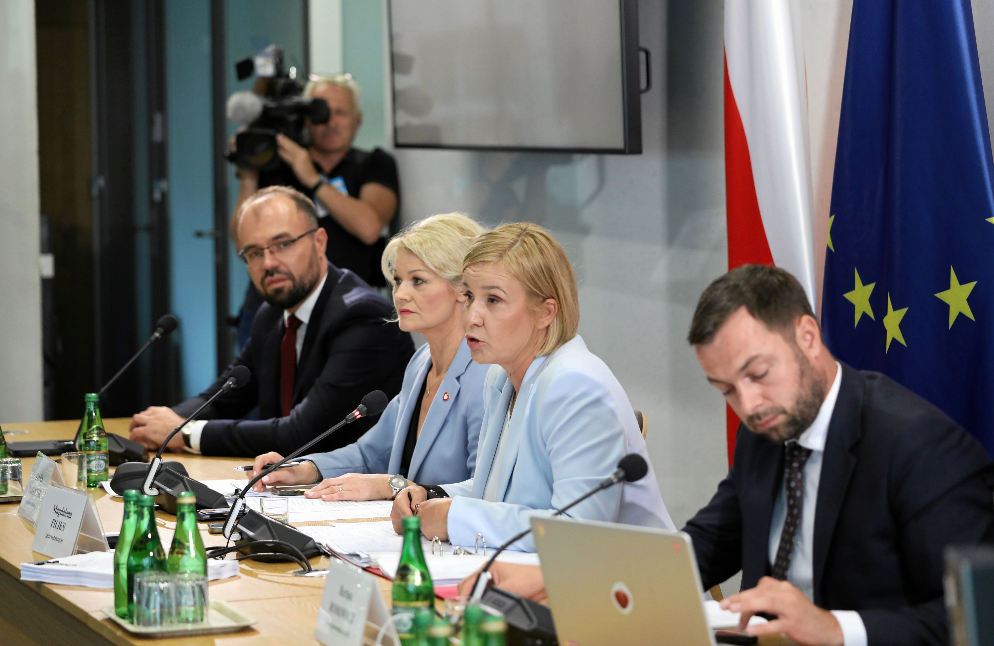 Dwóch mężczyzn i dwie kobiety przy stole. Kobieta w jasnoniebiskiej marynarce (Magdalena Filiks) prowadzi obrady