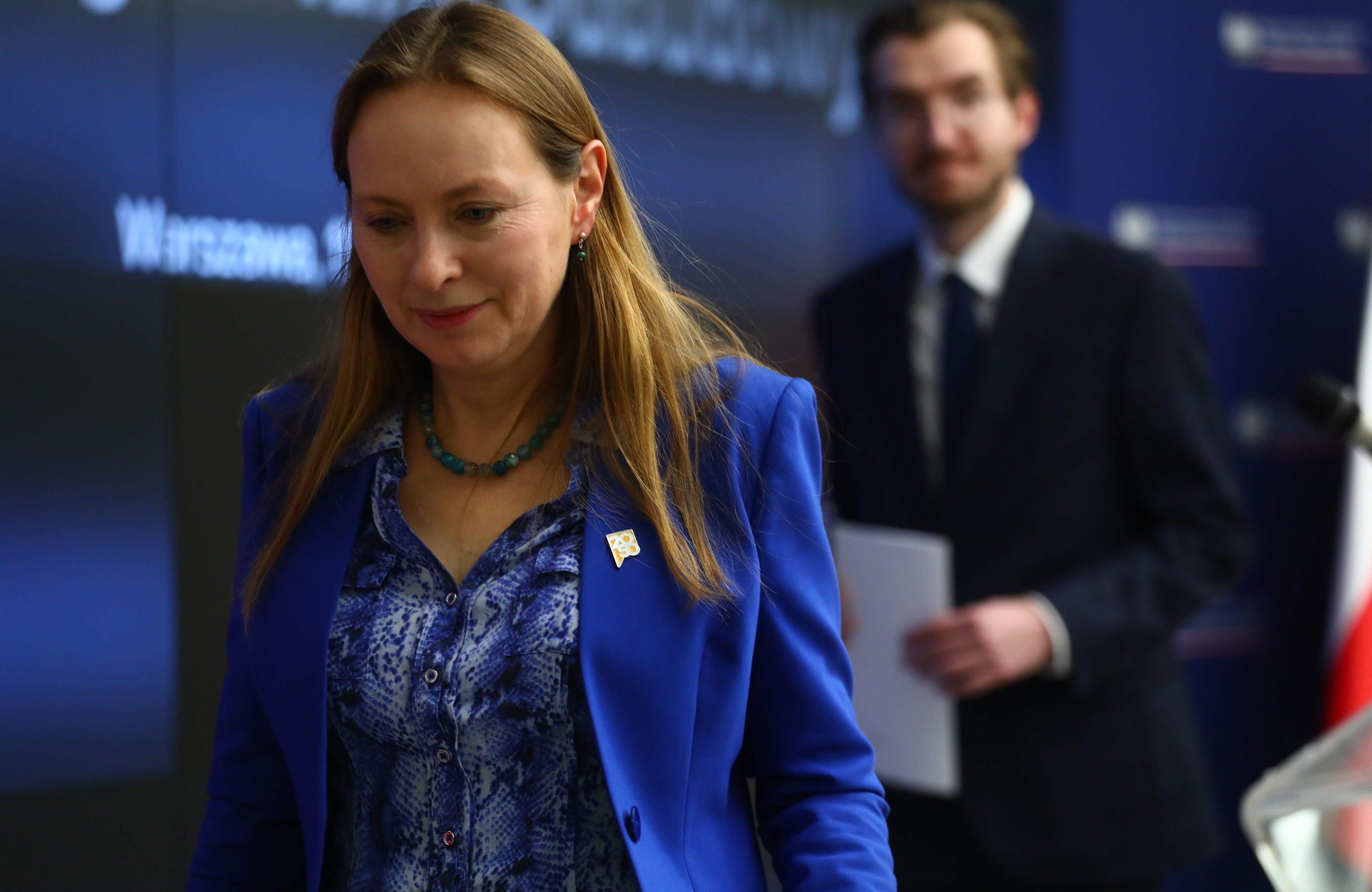 Kobieta z pochyloną głową w niebieskiej marynarce, za nią mężczyzna z kartką w ręku. Katarzyna Pełczyńska-Nałęcz i Jan Szyszko