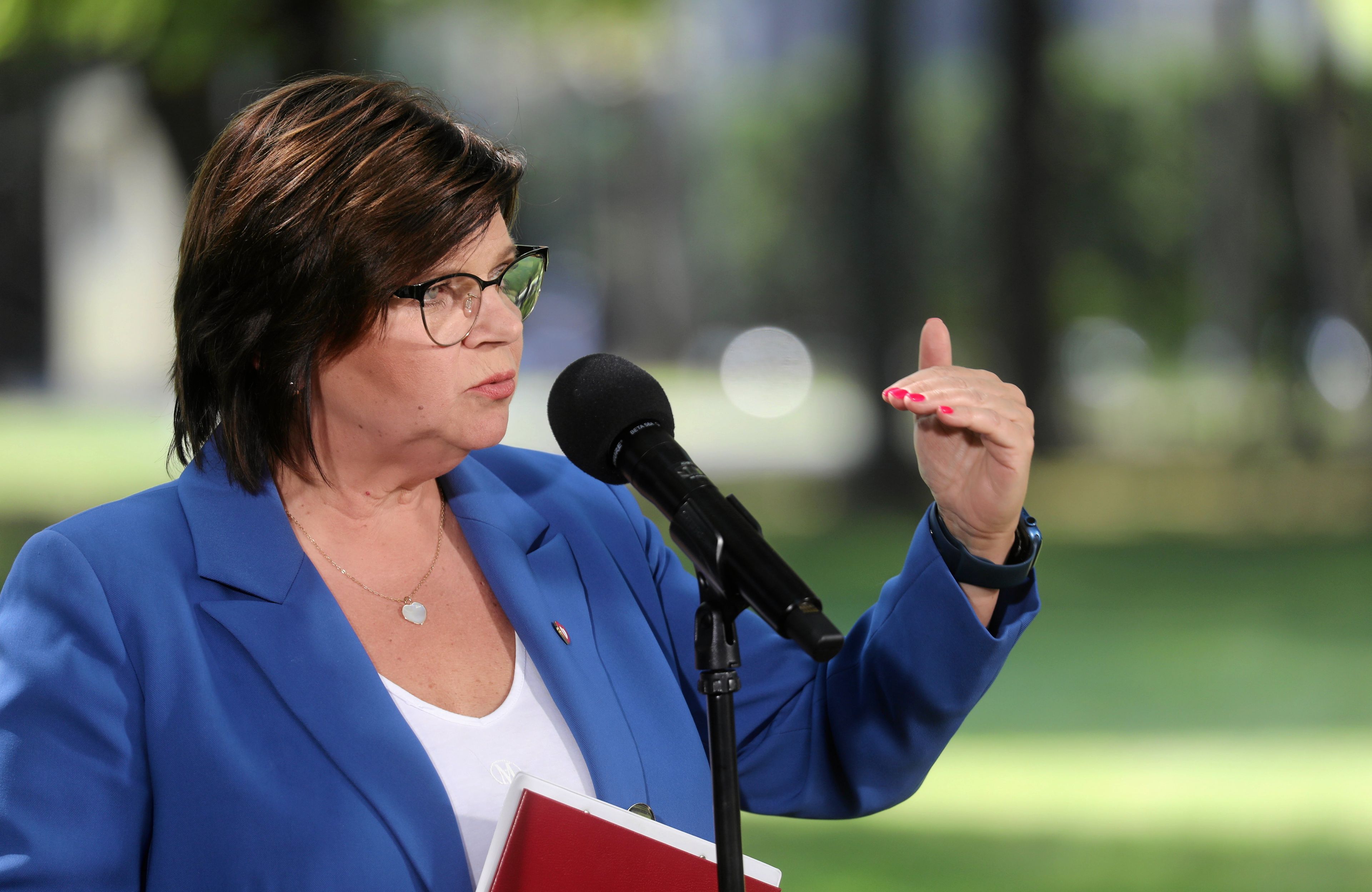 Kobieta w okularach przemawia, Izabela Leszczyna