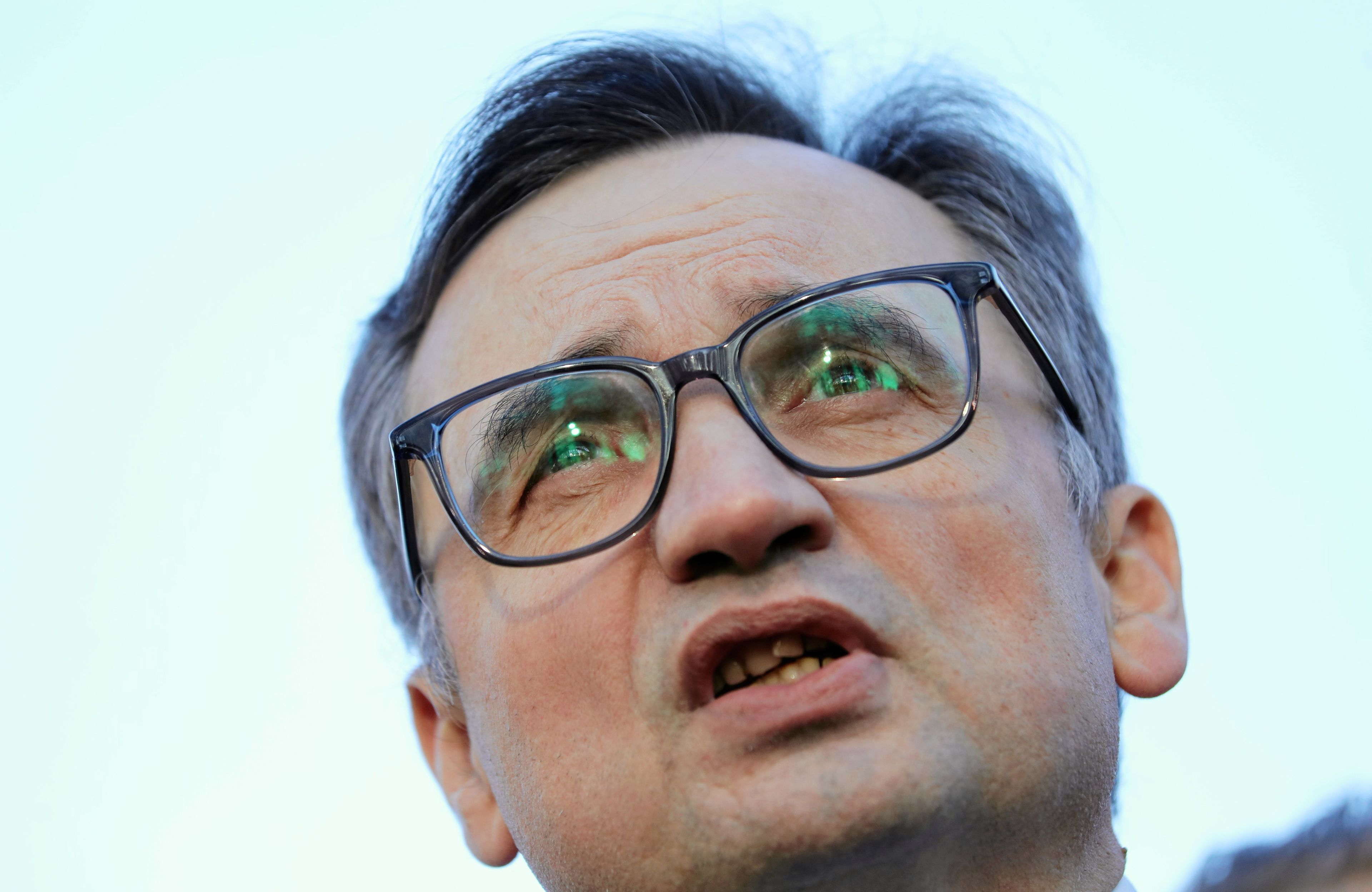 Mężczyzna w okularach, z otwartymi ustami, widać zęby