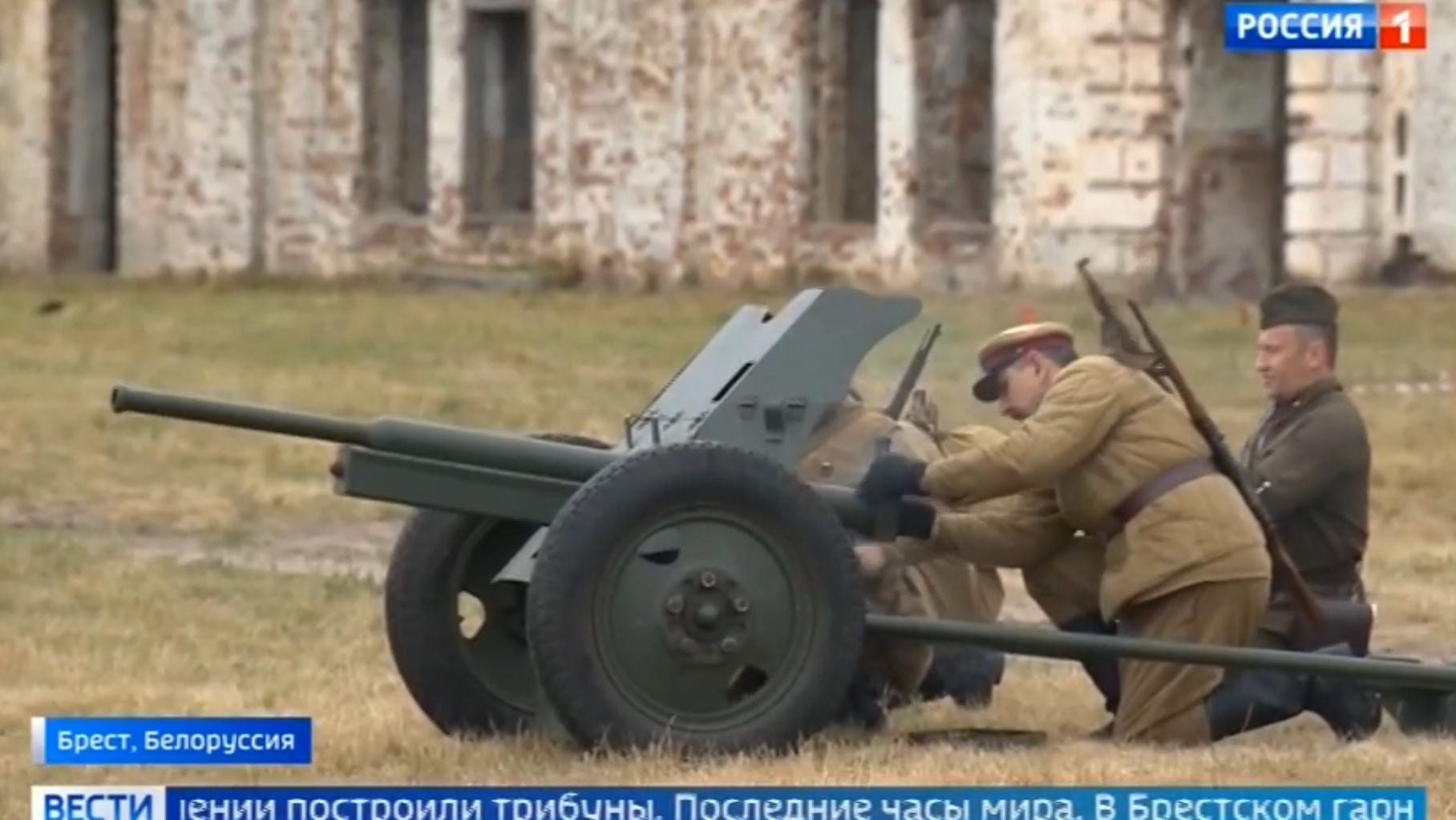 Ludzie w strojach historycznych żołnierzy Armii Czerwonej i armata