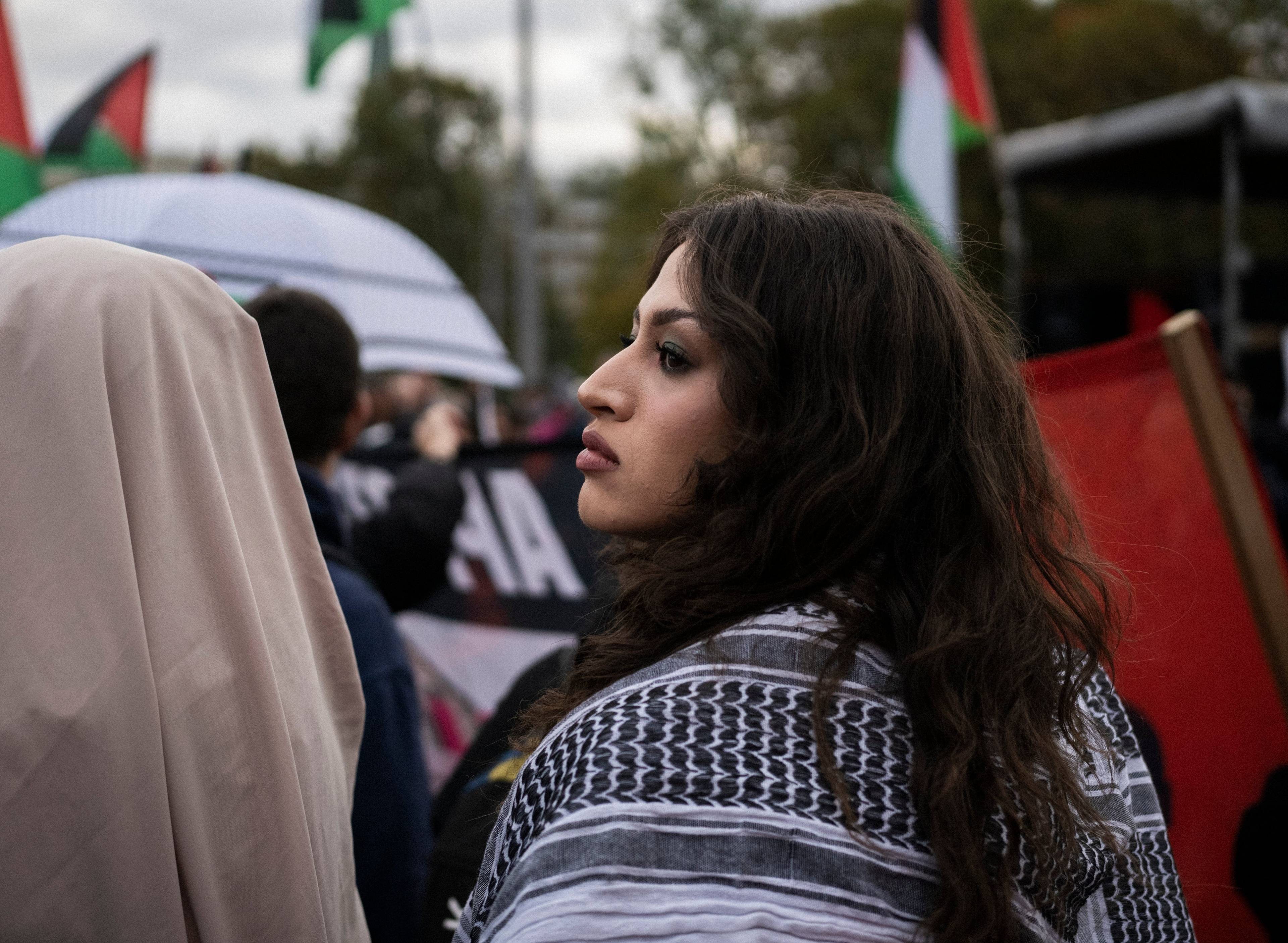 Dziewczyna z arafatką na ramionach w tłumie protestujących