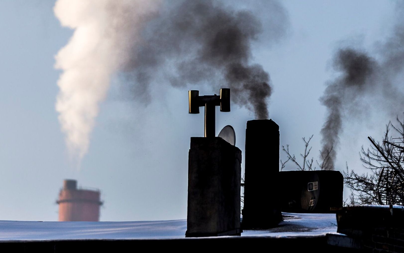 20.02.2021 Katowice . Niska emisja . Dymy z komina z piecow w kamienicach na tle komina elektrocieplowni .
 Fot. Grzegorz Celejewski / Agencja Gazeta