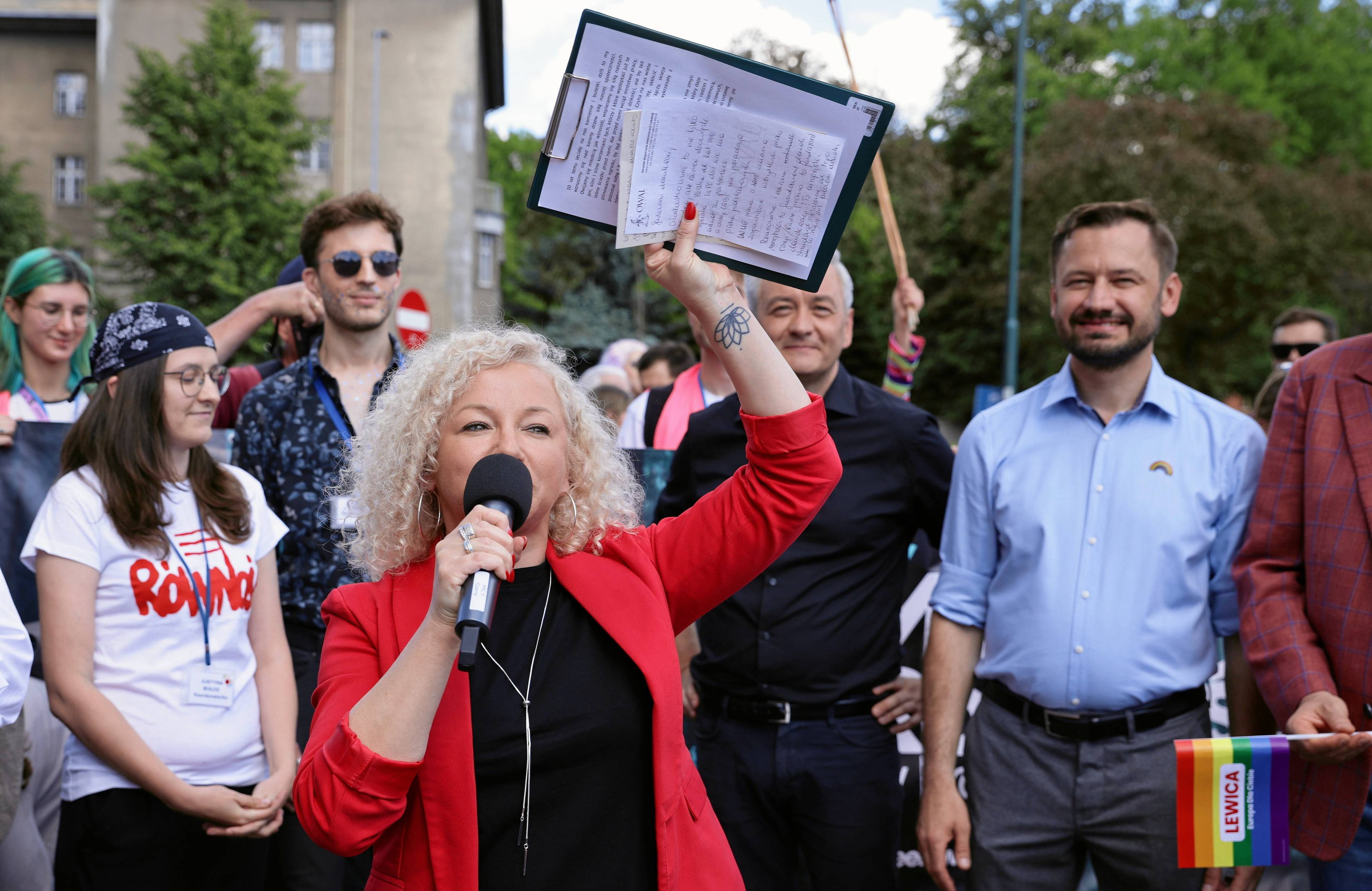 Katarzyna Kotula w czerwonej marynarce przemawia na Marszu Równości