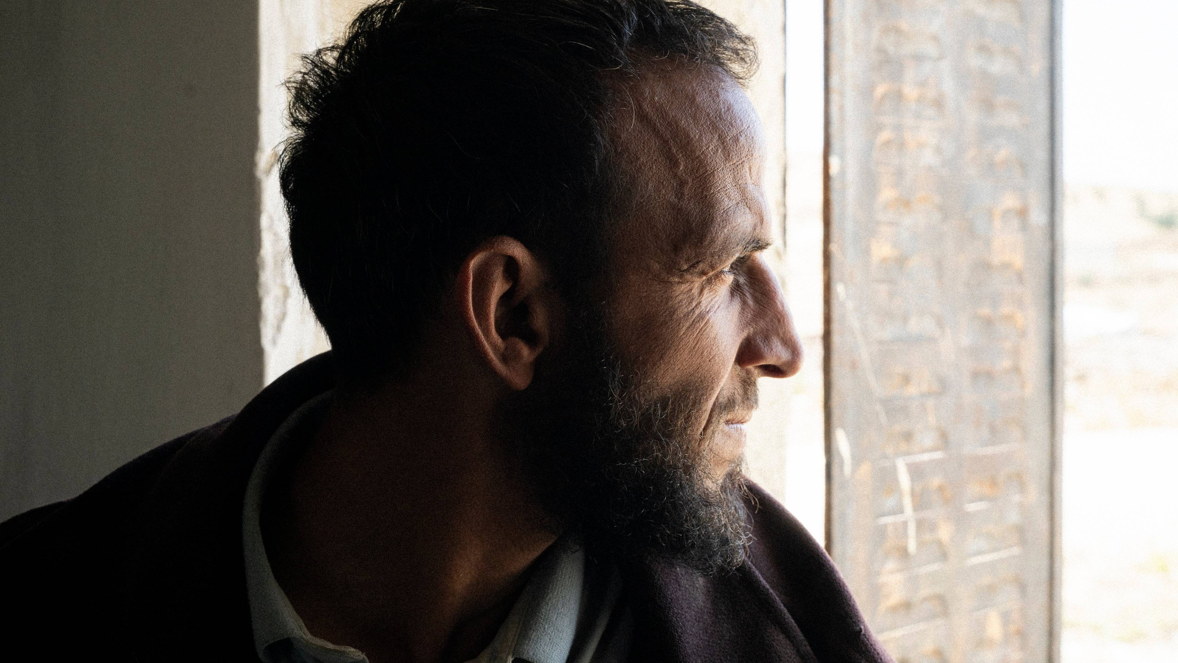 portret mężczyzny patrzącego przez okno.
