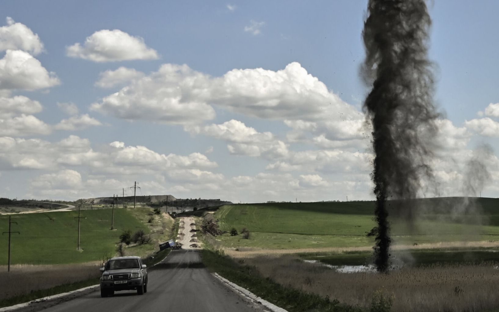 A mortar explodes next to the road leading to the city of Lysychansk in the eastern Ukranian region of Donbas, on May 23, 2022, amid Russian invasion of Ukraine. (Photo by ARIS MESSINIS / AFP)