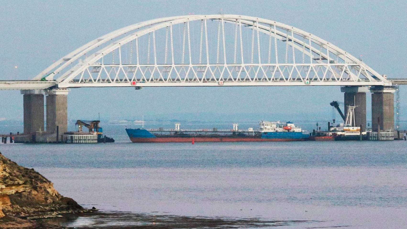 5711849 25.11.2018 A cargo ship blocks a passage under the arch of the Crimean bridge over Kerch Strait in Russia, November 25, 2018. On Sunday Russian authorities closed off the Kerch Strait after three Ukrainian naval ships had crossed the Russian border and entered the temporarily closed area of the Russian territorial waters. Andrej Krylov / Sputnik  via AP
