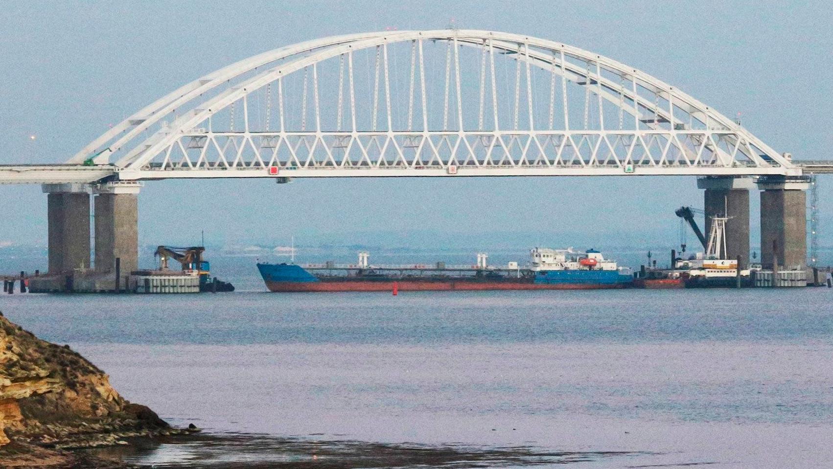 5711849 25.11.2018 A cargo ship blocks a passage under the arch of the Crimean bridge over Kerch Strait in Russia, November 25, 2018. On Sunday Russian authorities closed off the Kerch Strait after three Ukrainian naval ships had crossed the Russian border and entered the temporarily closed area of the Russian territorial waters. Andrej Krylov / Sputnik  via AP