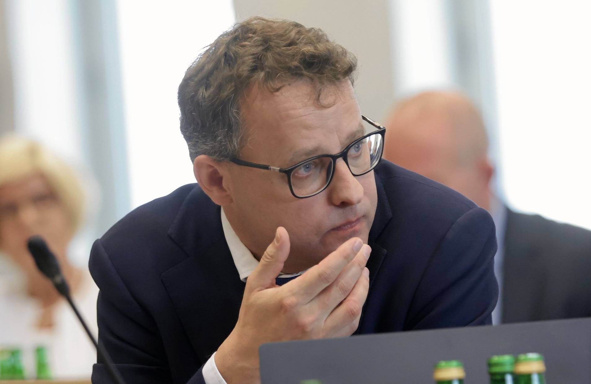 Marcin Romanowski podczas prac sejmowej komisji, spogląda zaniepokojony w lewo
