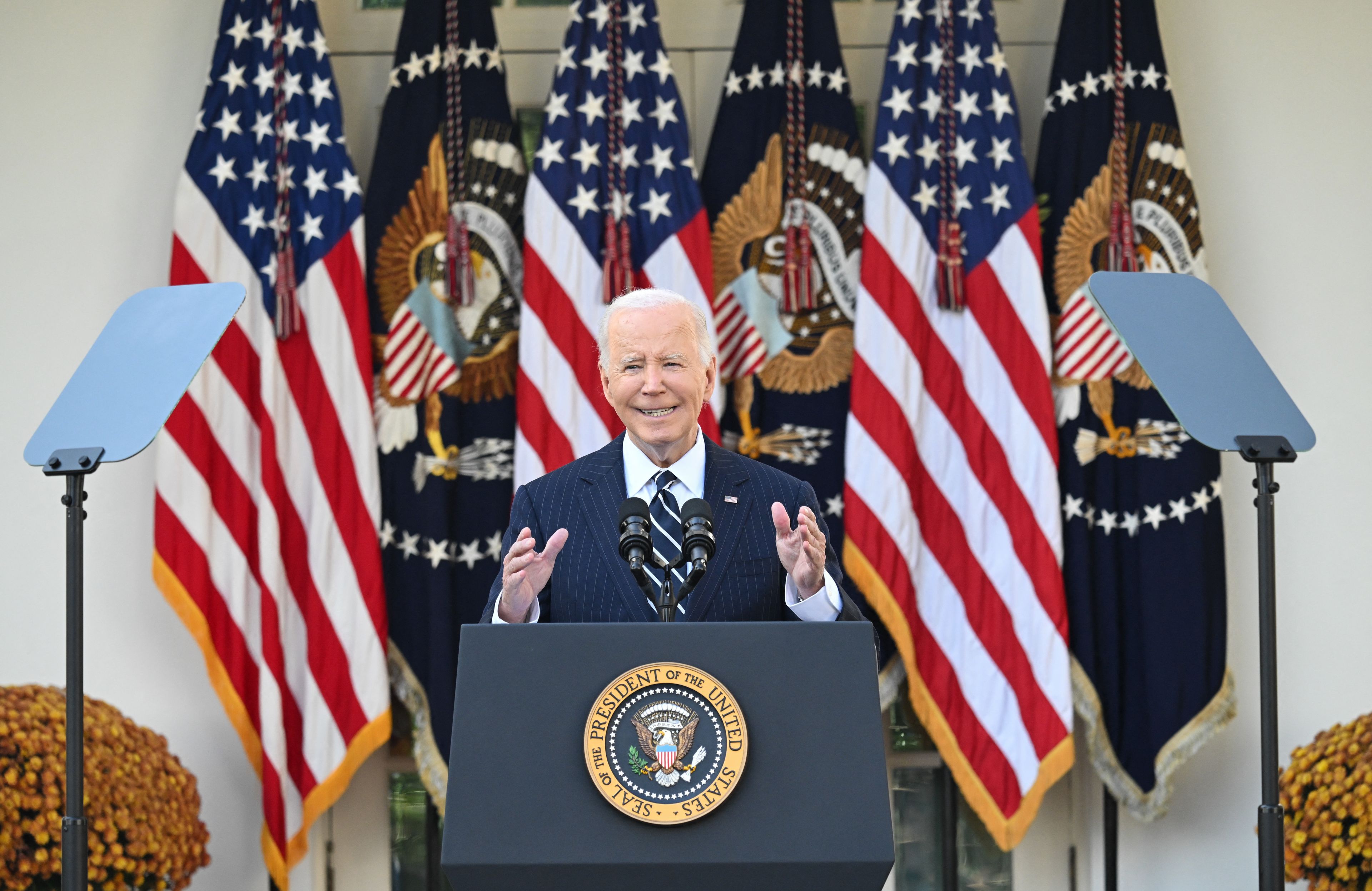 Prezydent Biden przemawia przed Białym Domem na tle flag Stanów Zjednoczonych