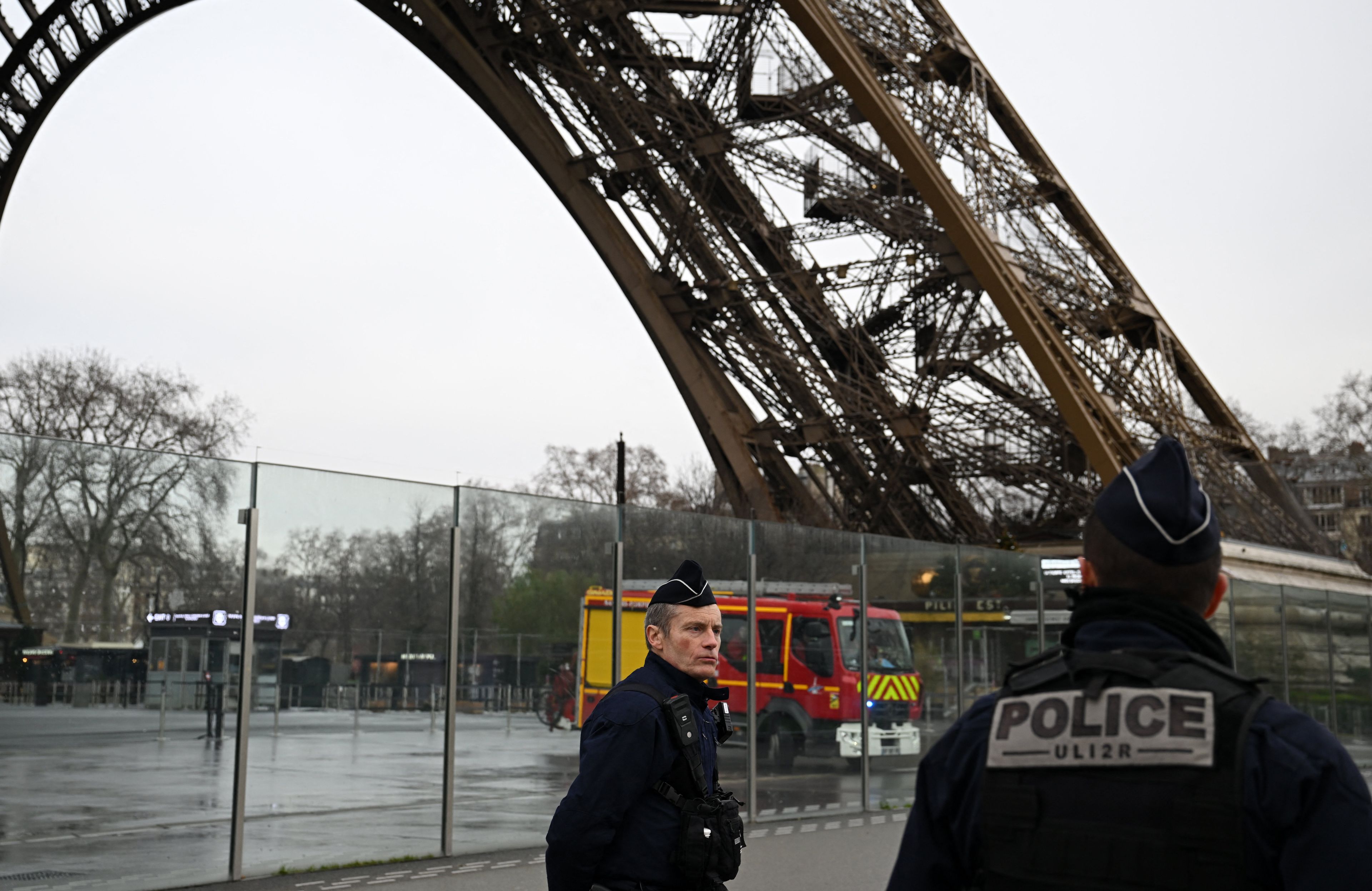 Francuska policja i strażacy stoją u podnóża wieży Eiffla, gdzie odnotowano pożar.