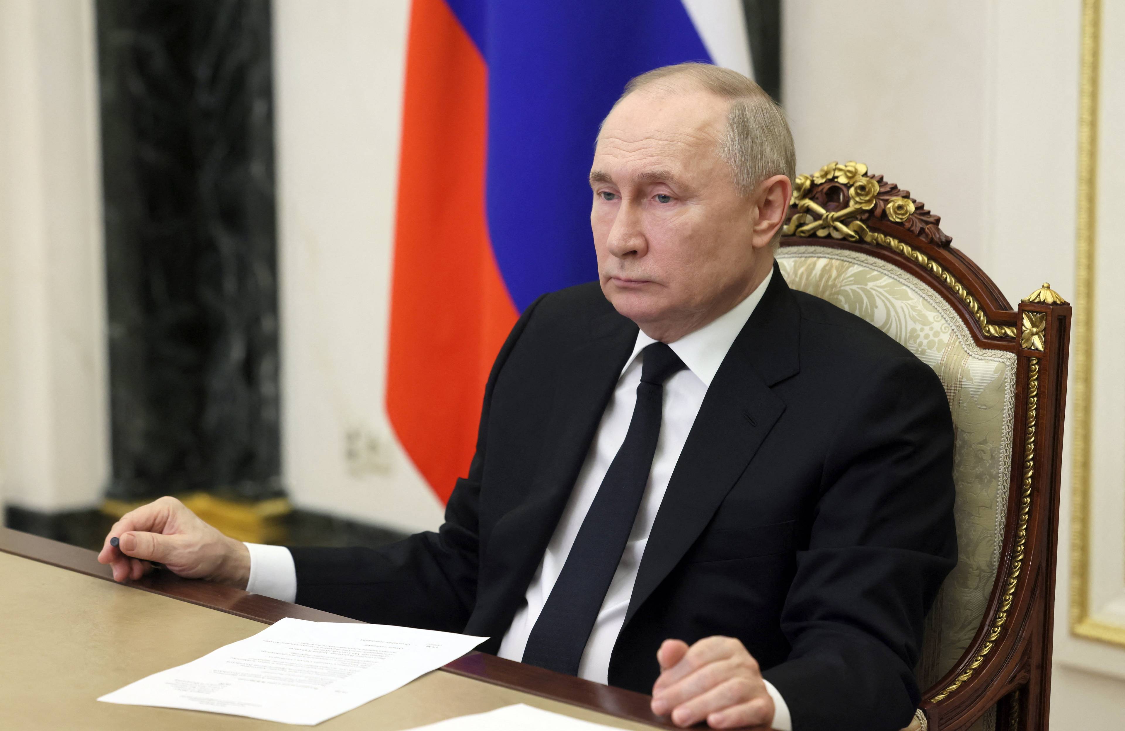 Władimir Putin siedzi za stołem
