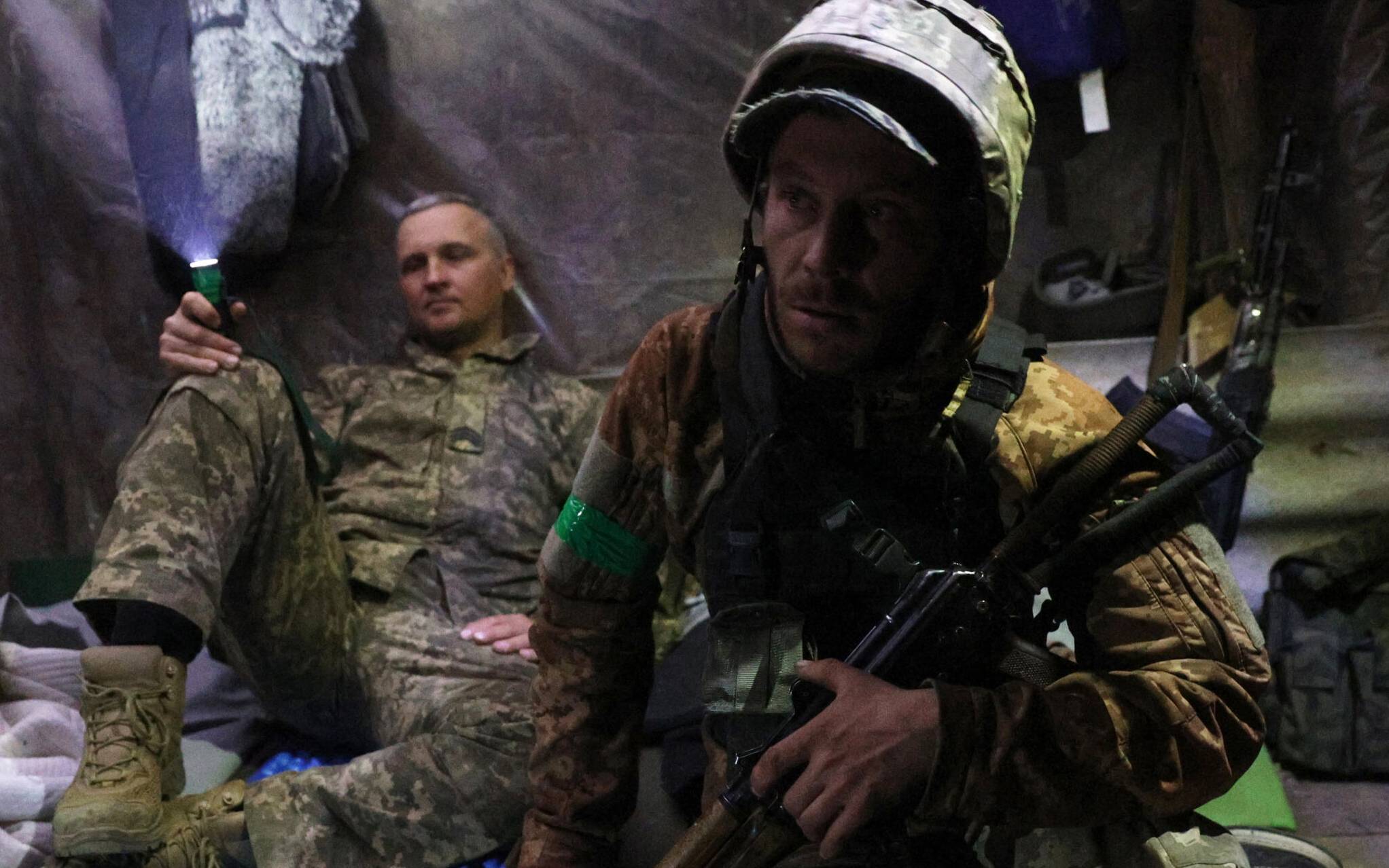 Servicemen of the Ukrainian Military Forces wait out shelling in a shelter on a position near Lysychansk in the Luhansk region on April 12, 2022. (Photo by Anatolii Stepanov / AFP)