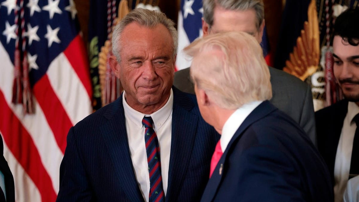WASHINGTON, DC - NOVEMBER 13: President Donald Trump, shakes hands with Health and Human Services Secretary Robert F. Kennedy Jr. alongside Secretary of Housing and Urban Development Scott Turner (L) after Trump signed the "Fostering the Future" executive order the East Room of the White House on November 13, 2025 in Washington, DC. The executive order, championed by first lady Melania Trump, works to expand opportunities for education, career development, housing and other resources for youth transitioning from foster care to adulthood.   Heather Diehl/Getty Images/AFP (Photo by Heather Diehl / GETTY IMAGES NORTH AMERICA / Getty Images via AFP)