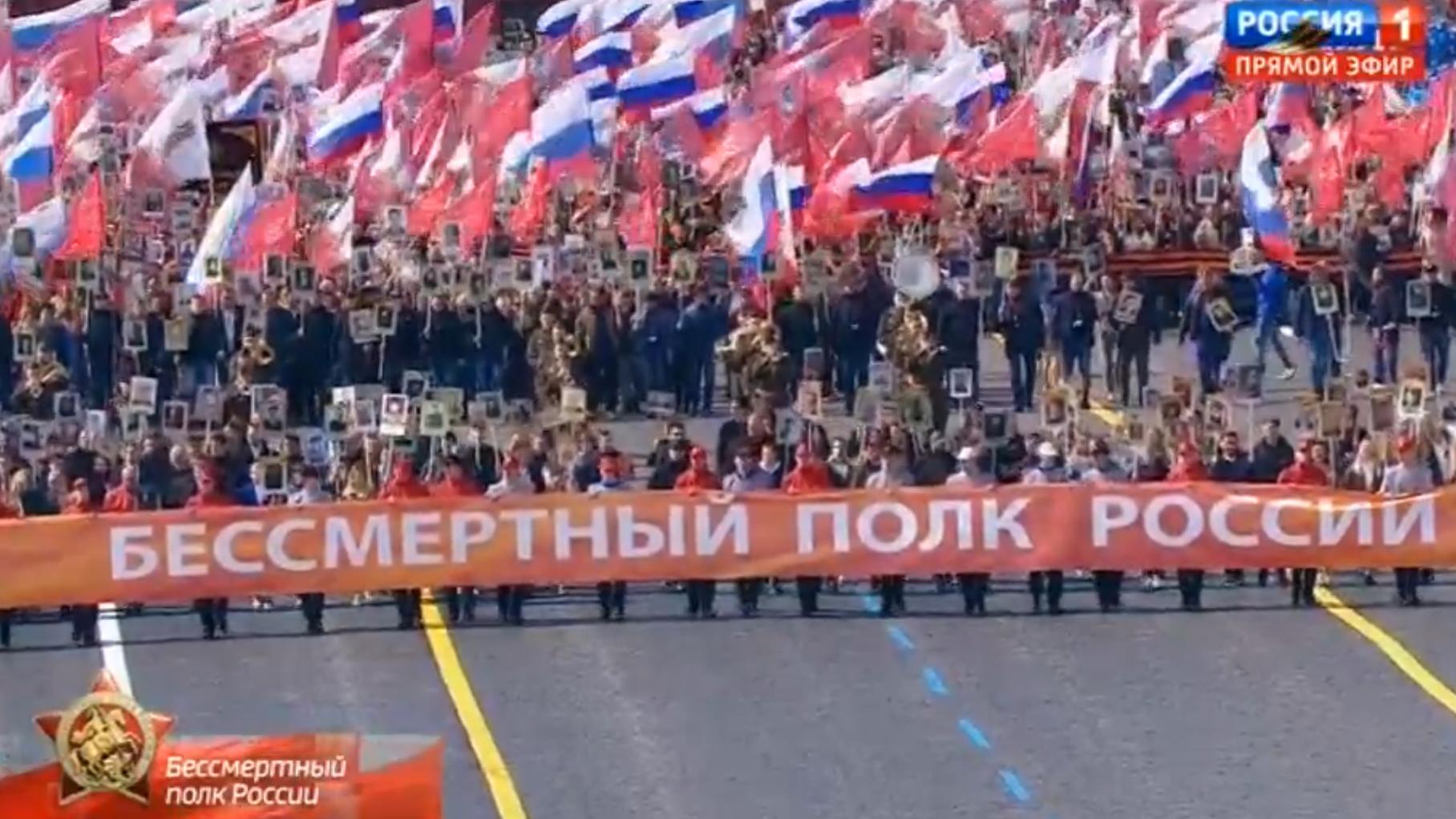 Ludzie niosą flagi Rosji. Czoło marszu z napisem "Nieśmiertelny Pułk Rosji"