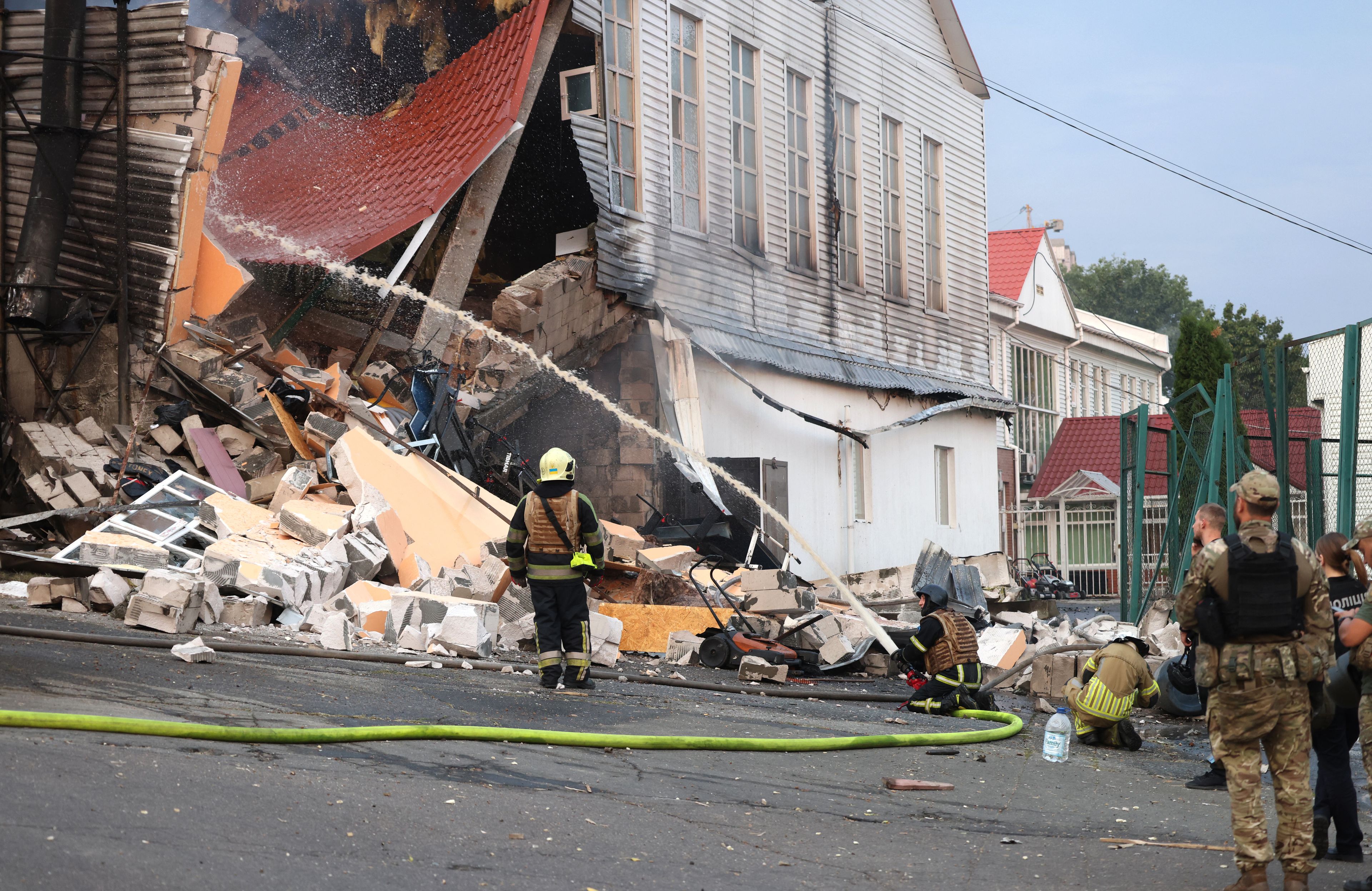 Zniszczony budynek w Kijowie w wyniku rosyjskiego ataku, strażacy gaszą pożar