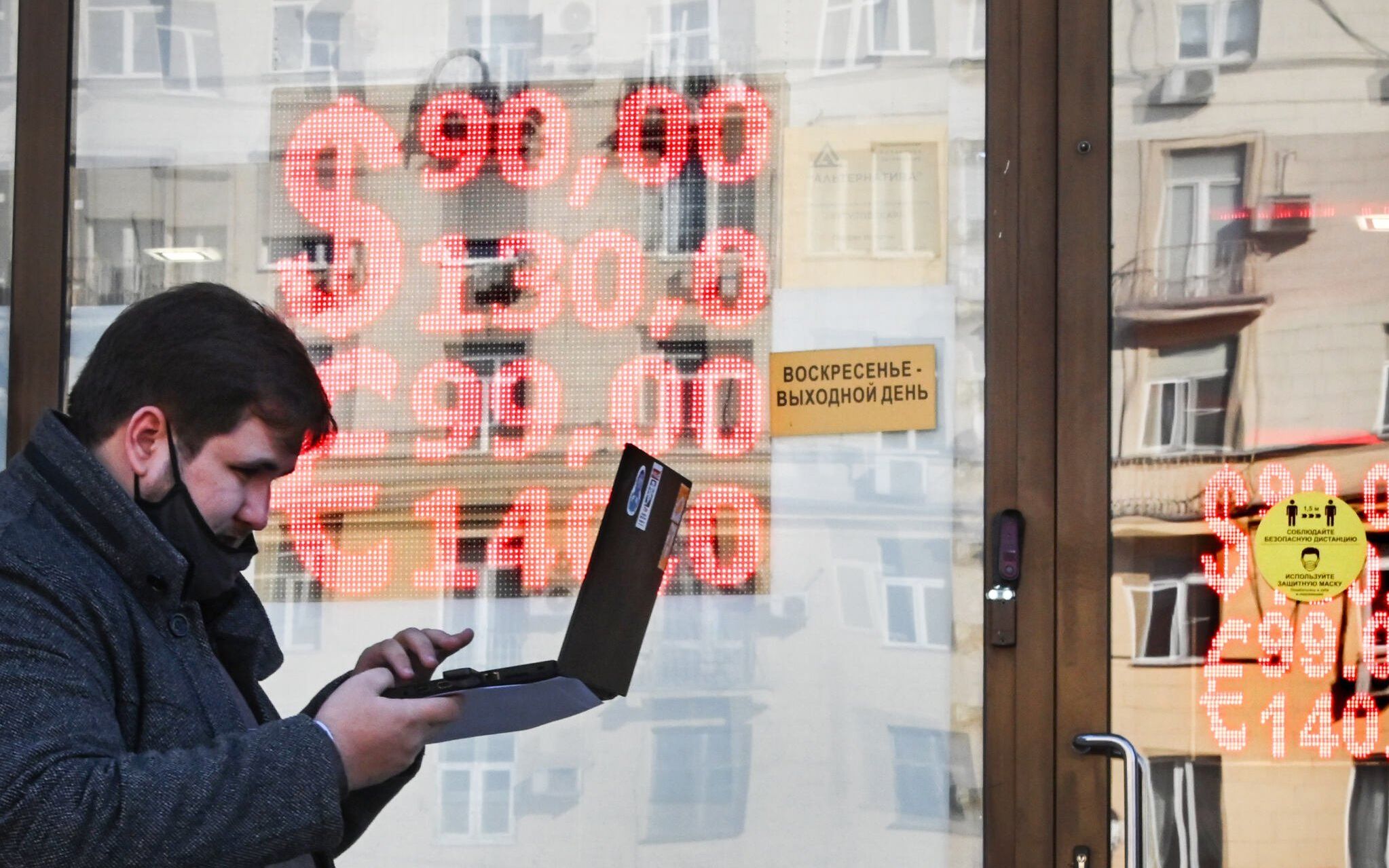 A man walks past a currency exchange office in central Moscow on February 28, 2022. - The Russian ruble collapsed against the dollar and the euro on the Moscow Stock Exchange on February 28 as the West punished Moscow with harsh new sanctions over the Kremlin's invasion of Ukraine. The ruble fell sharply at the start of currency trading, reaching 100.96 to the dollar, compared to 83.5 on Wednesday, the day before the invasion of Ukraine, and 113.52 to the euro, compared to 93.5 before the assault. (Photo by Alexander NEMENOV / AFP)