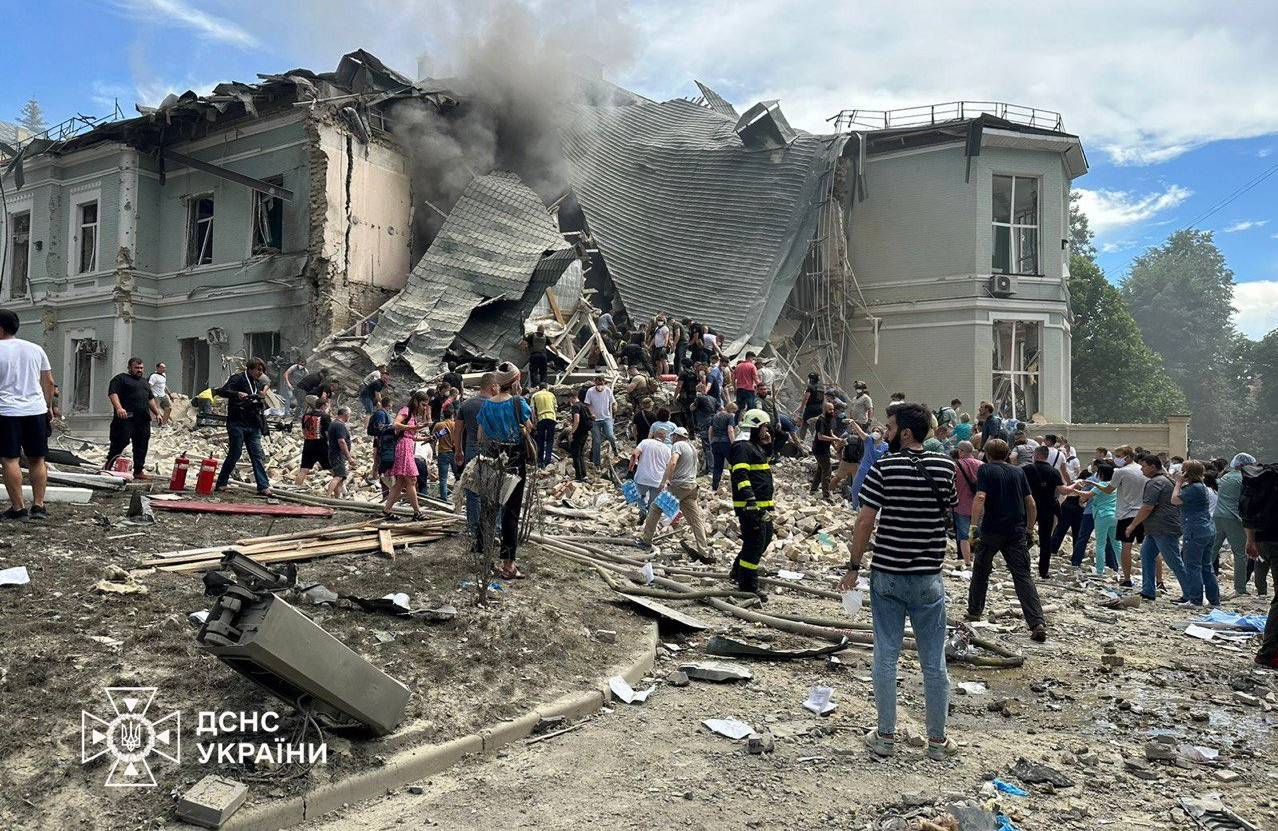 Na zdjęciu są gruzy budynku i ludzie, którzy je rozbierają . To akcja ratownicza w Kijowie
