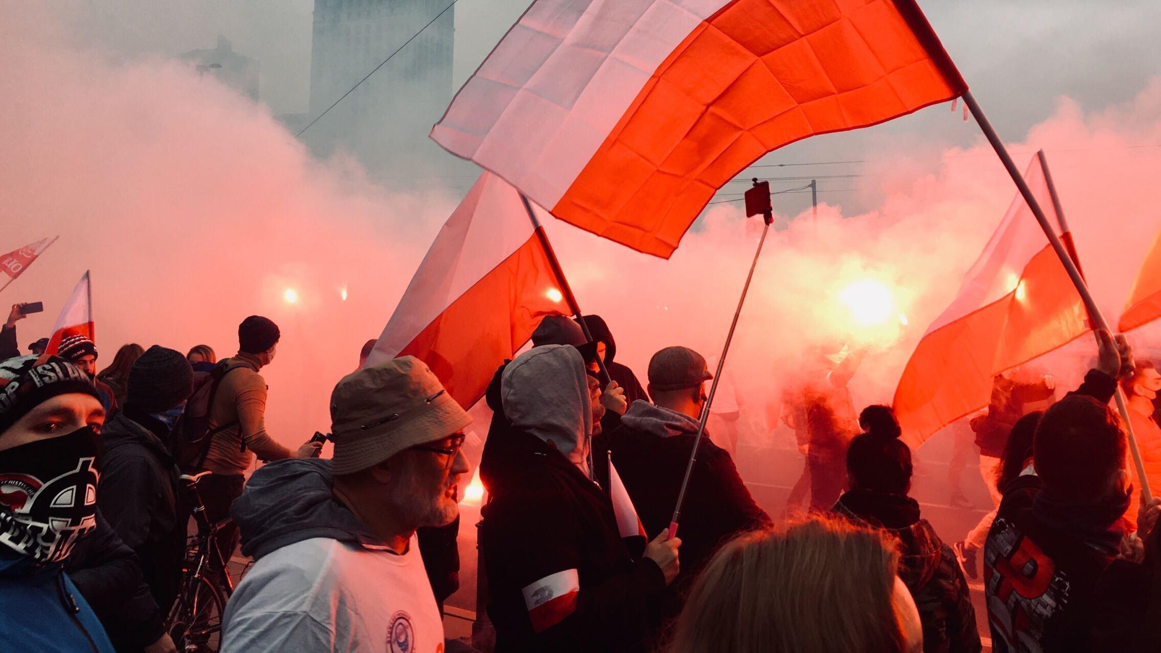 Uczestnicy marszu niepodległości maszerują przez Warszawę
