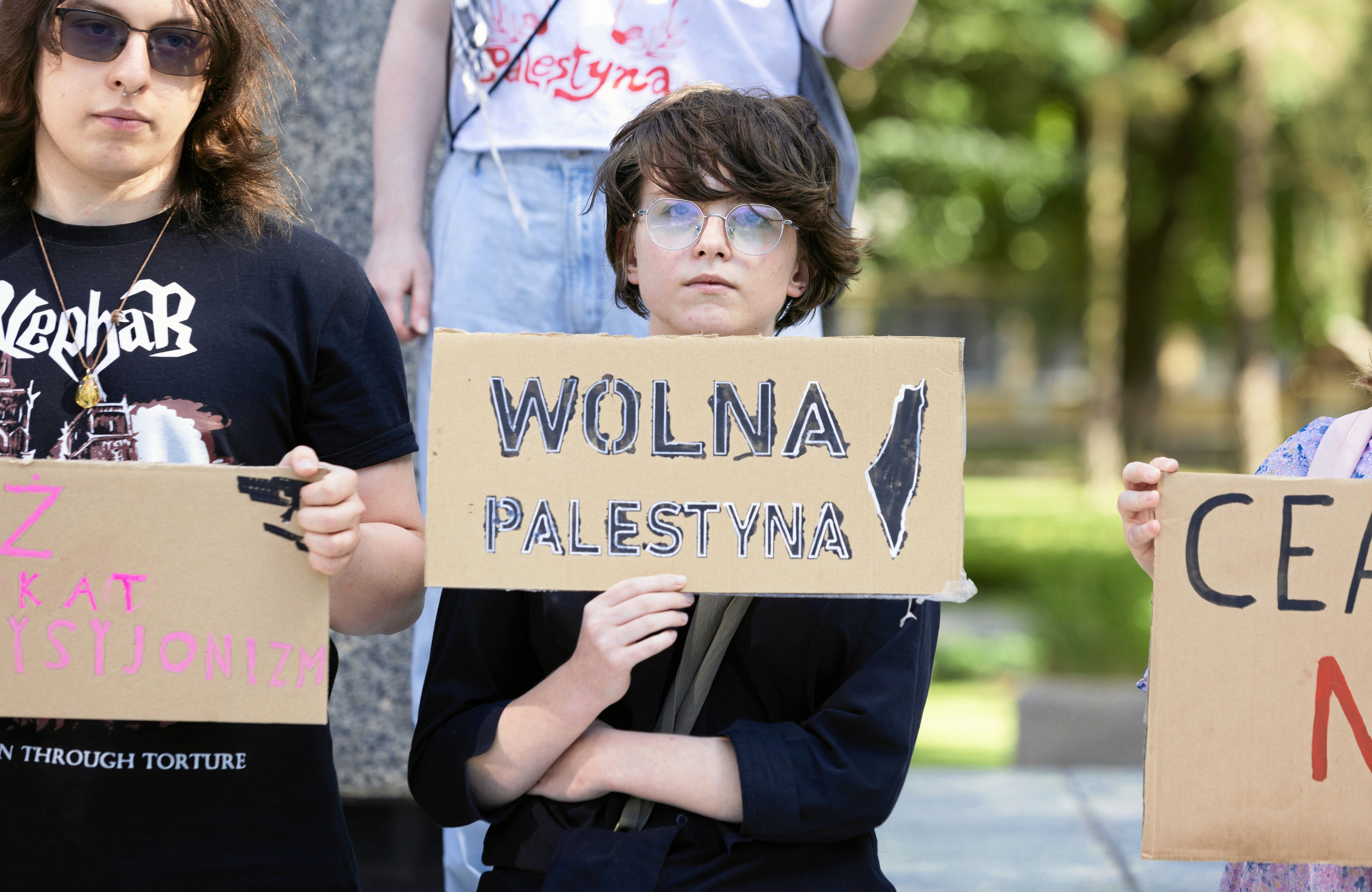 Młoda osoba trzymająca plakat z napisem „Wolna Palestyna"
