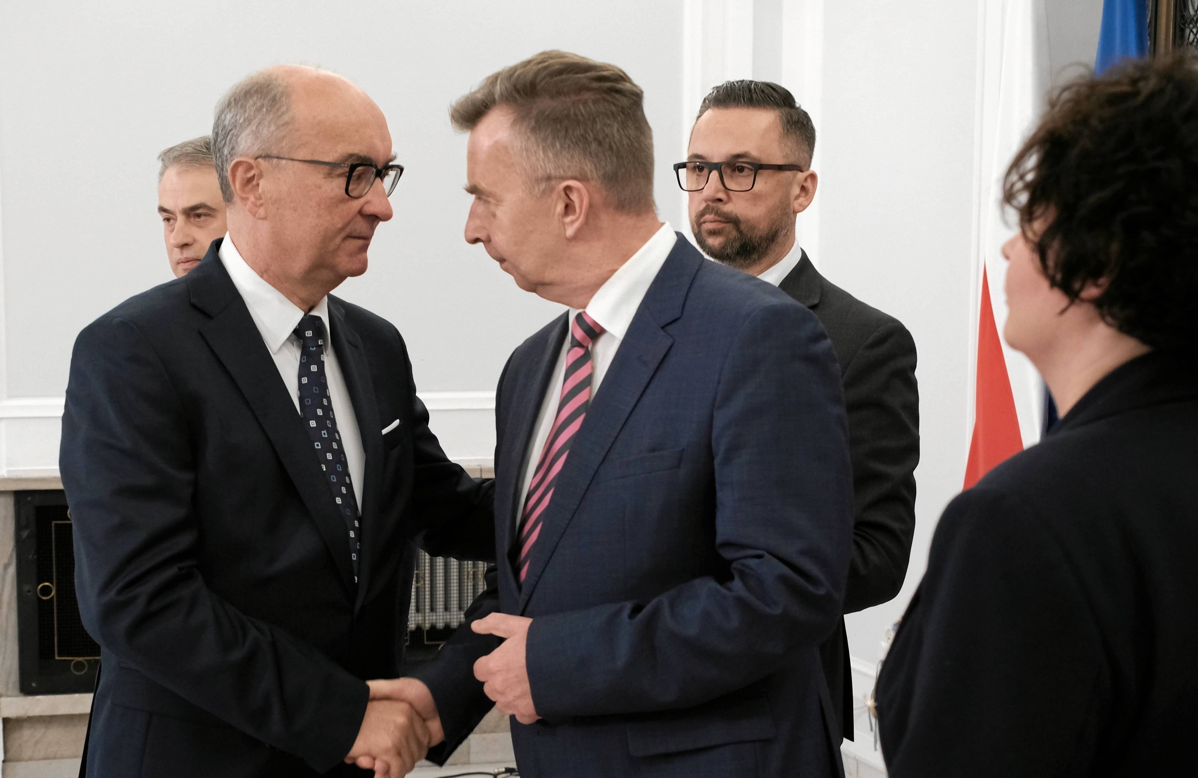 Mężczyźni w garniturach, typowi politycy, ściskający sobie dłonie