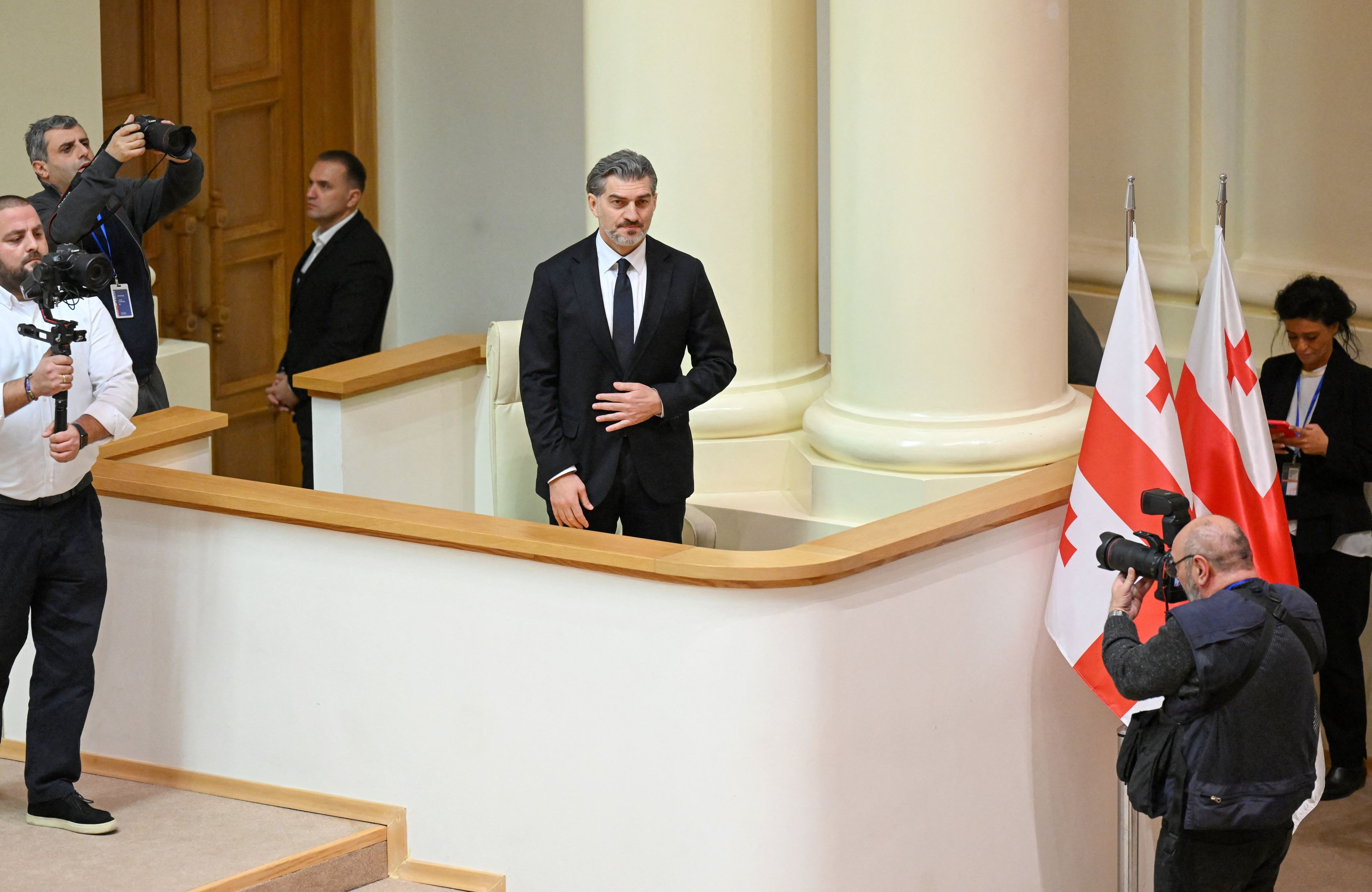 nowy prezydent gruzji w garniturze, wokół flagi gruzji