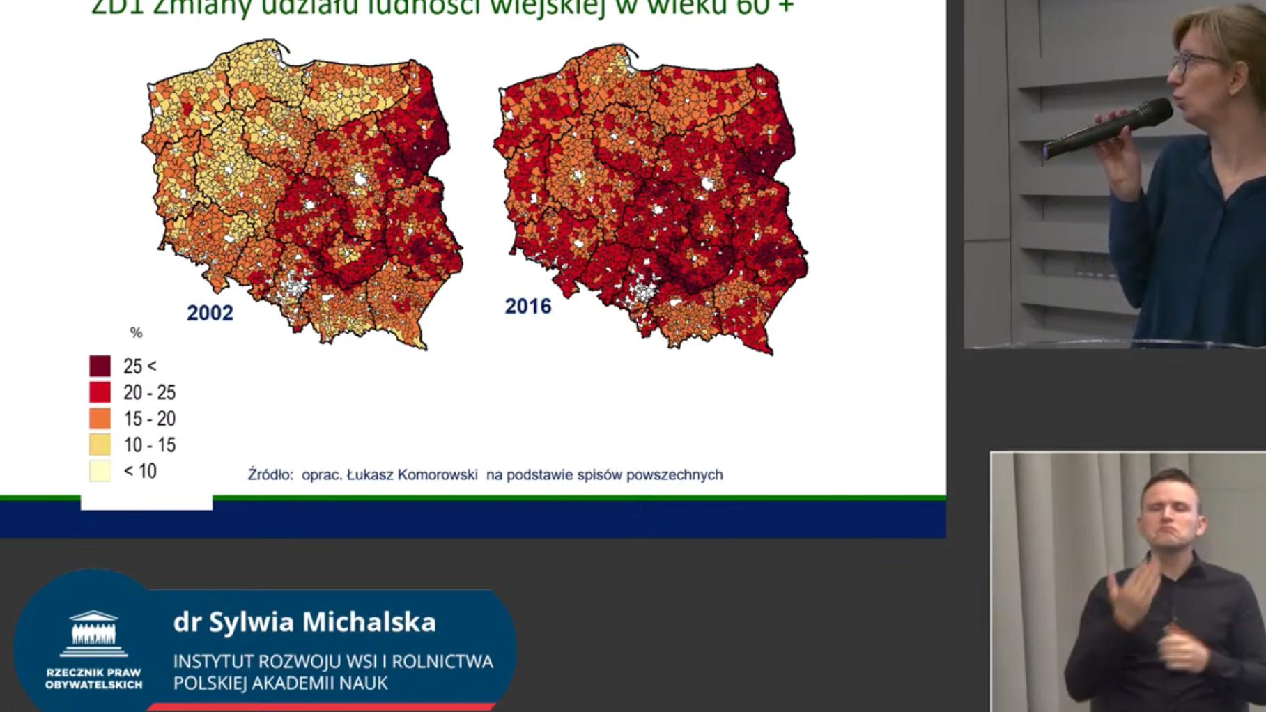 Kobieta pokazuje prezentację, obok tłomaczka PJM. Na prezentacji dwie mapy Polski, z 2002 r i z 2016 r. pokazujące, jak starzeje się przede wszystkim Polska wschodnia i środkowa