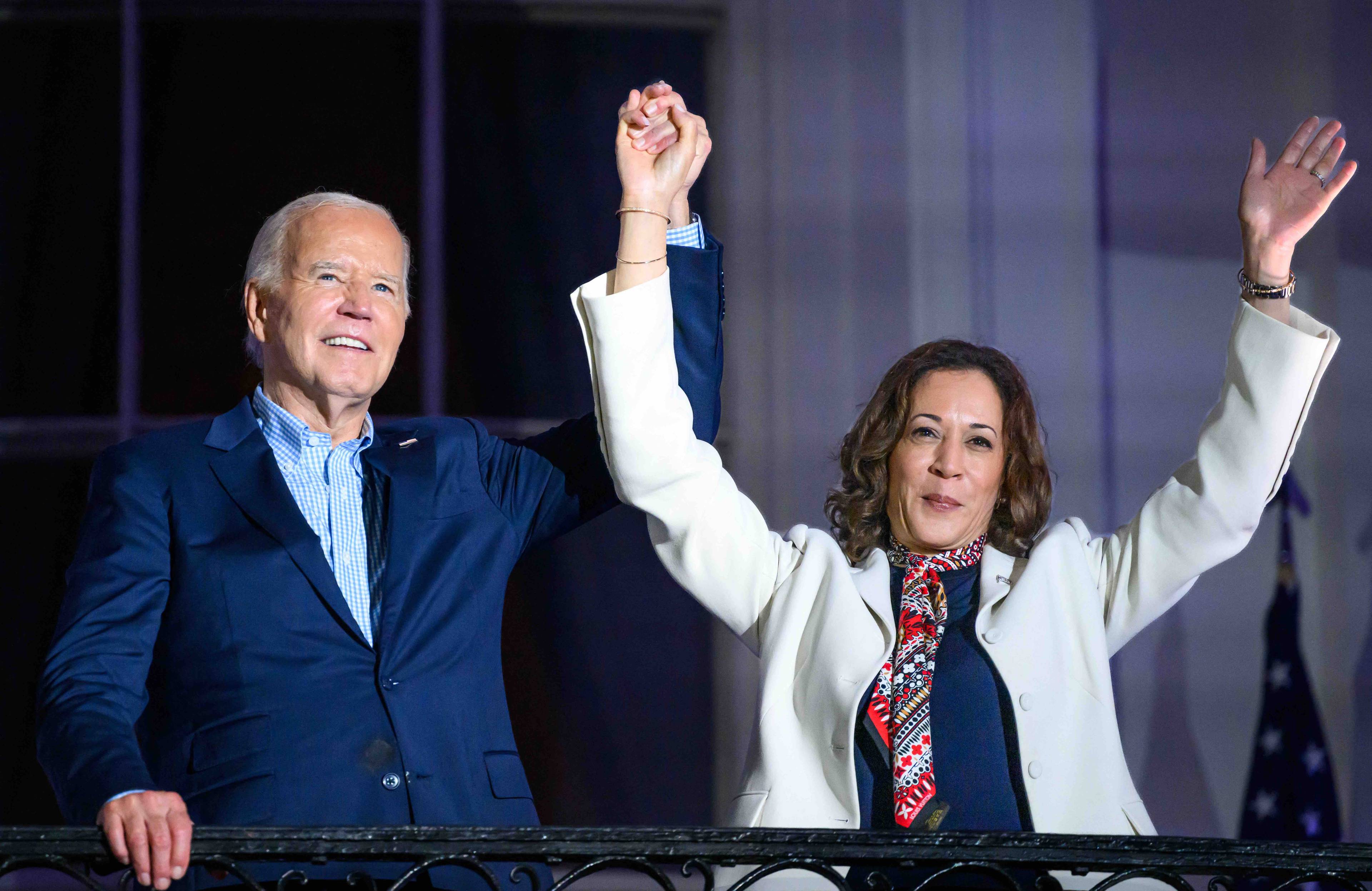 Joe Biden stoi z Kamalą Harris na scenie podczas wiecu wyborczego, wznosi do góry jej rękę