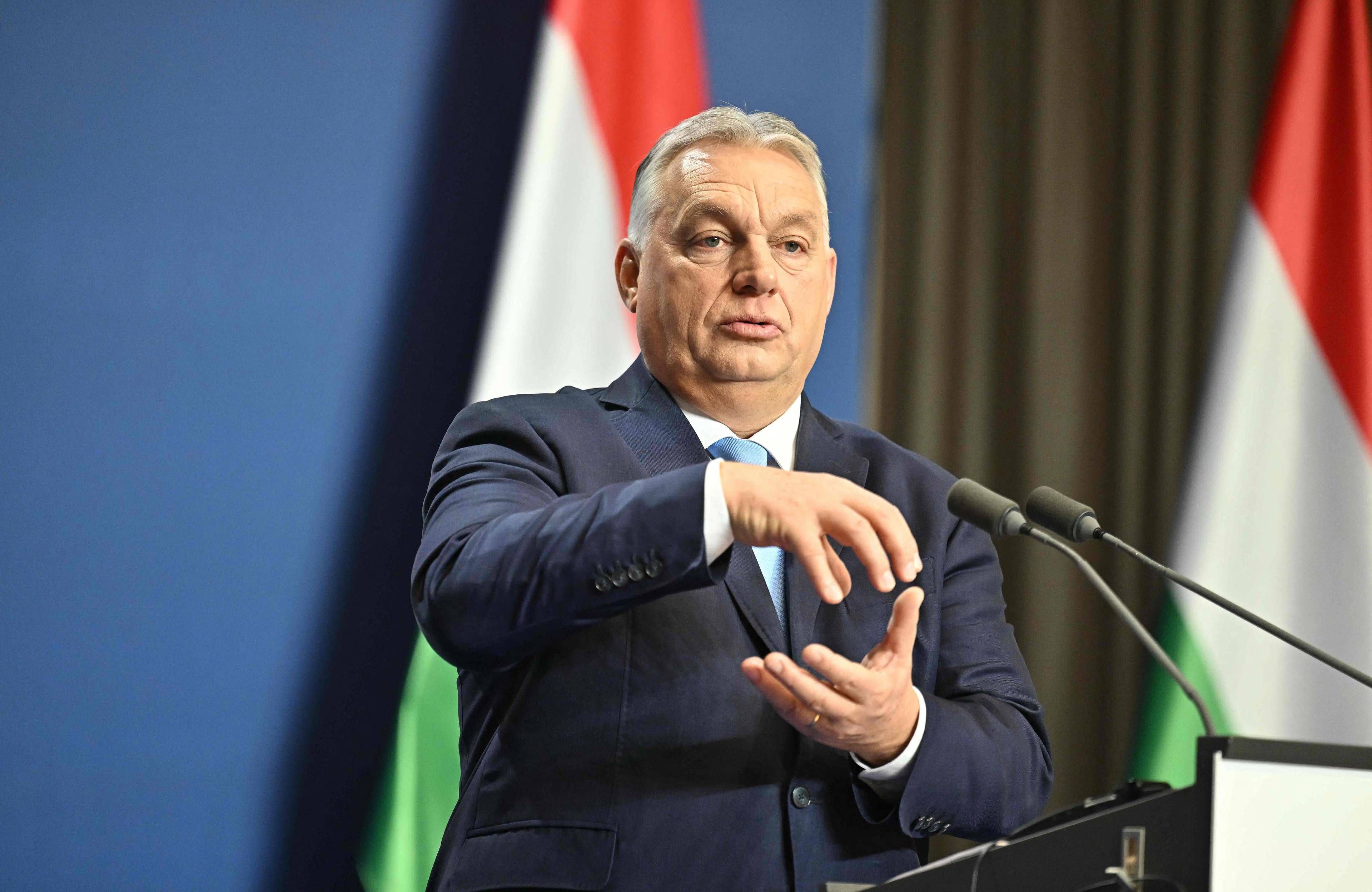 Siwy mężczyzna w garniturze gestykuluje