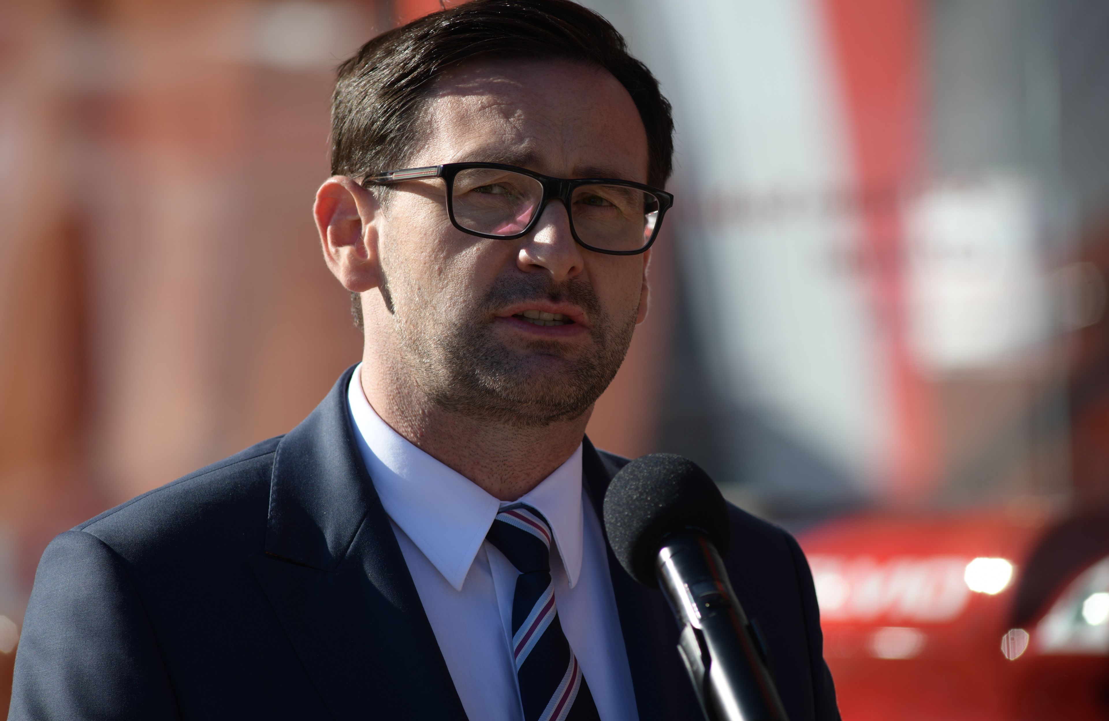 Daniel Obajtek podczas konferencji prasowej na zewnątrz w słońcu