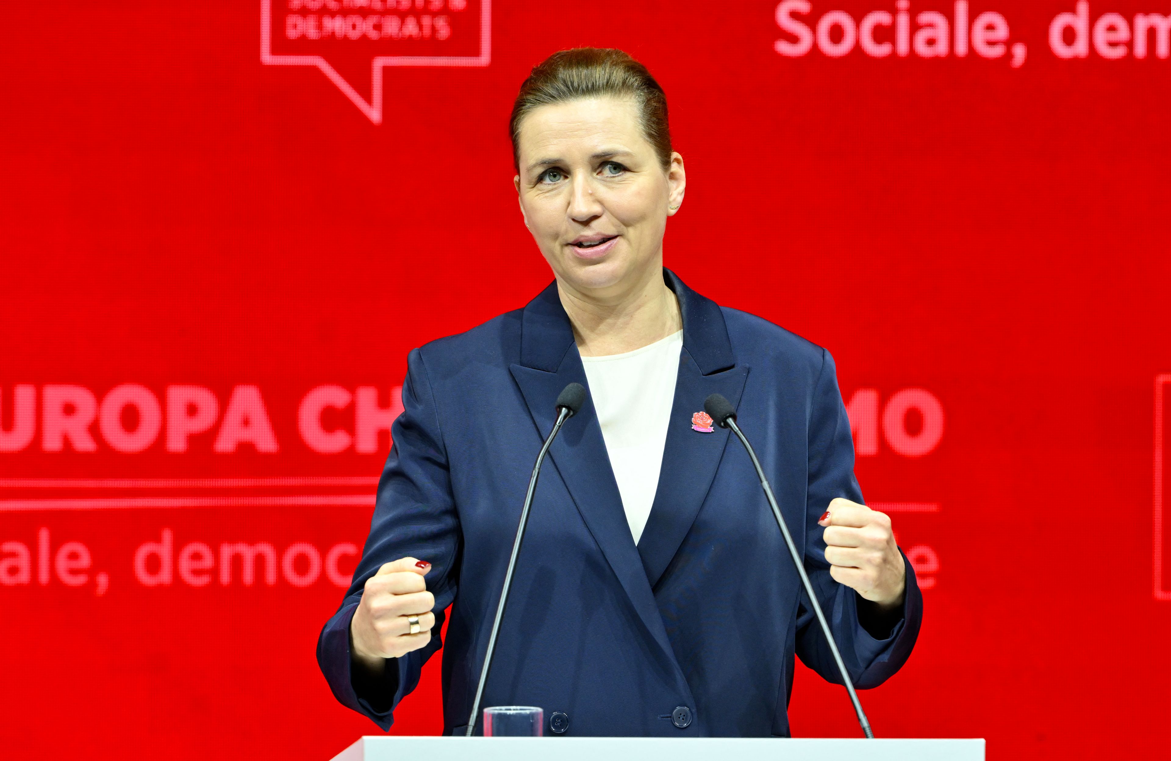 Kobieta w średnim wieku przemawia na czerwonym tle