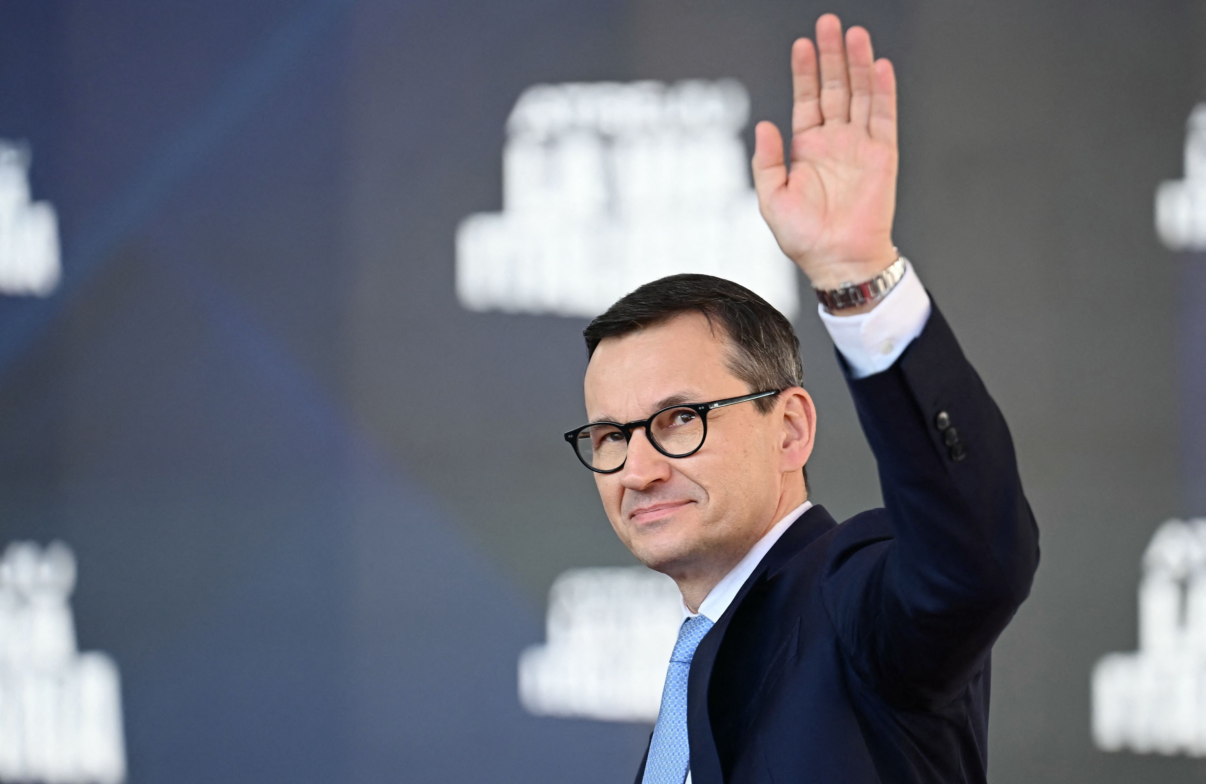 Mężczyna w oklulrach z podniesiona ręką