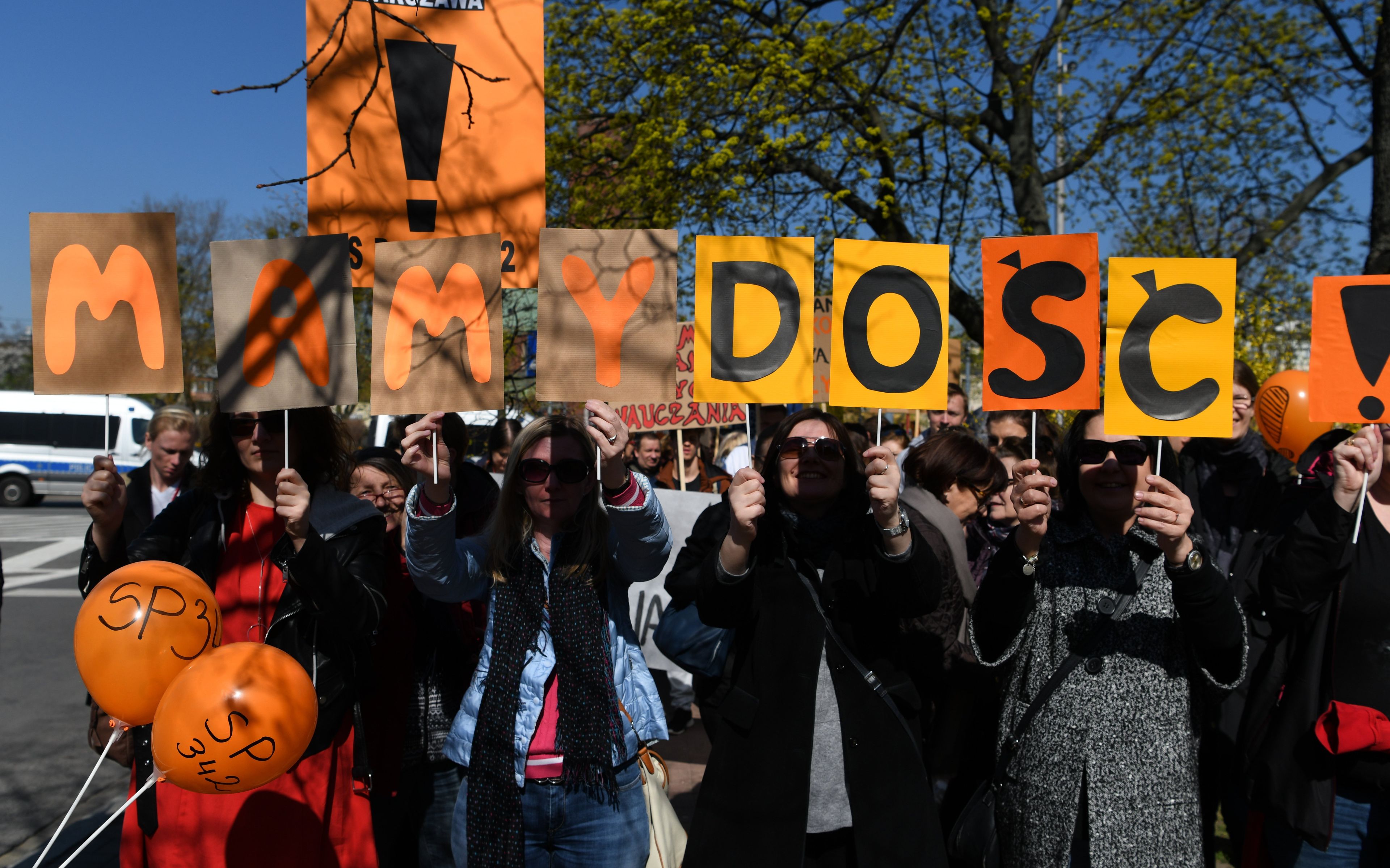 Grupa osób niesie transparent z napisem Dość