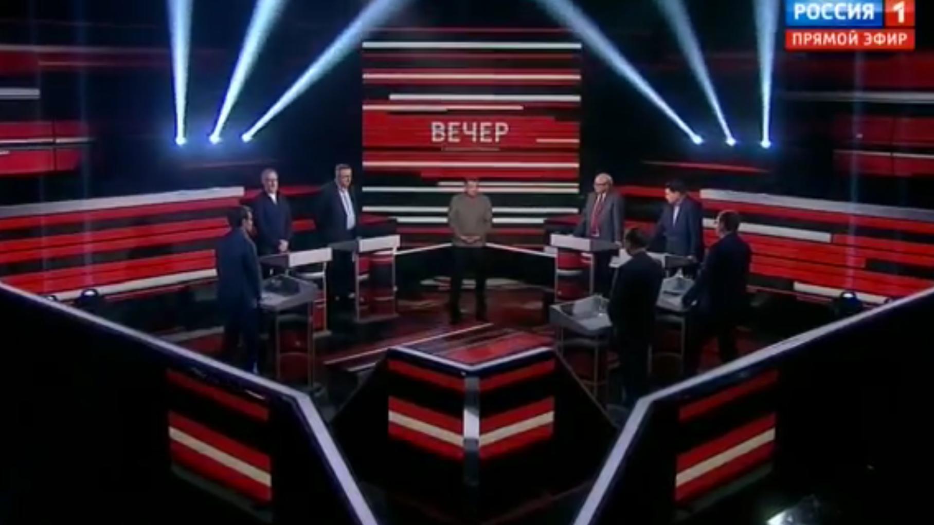 Mężczyźni stoją w studiu telewizyjnym, w środku - mężczyzna w szarej kurtce (Sołowiow)