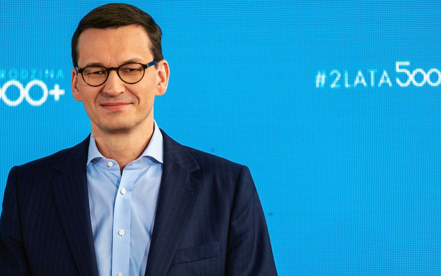 Premier Morawiecki na tle monitora z napisem 2 lata 500 plus