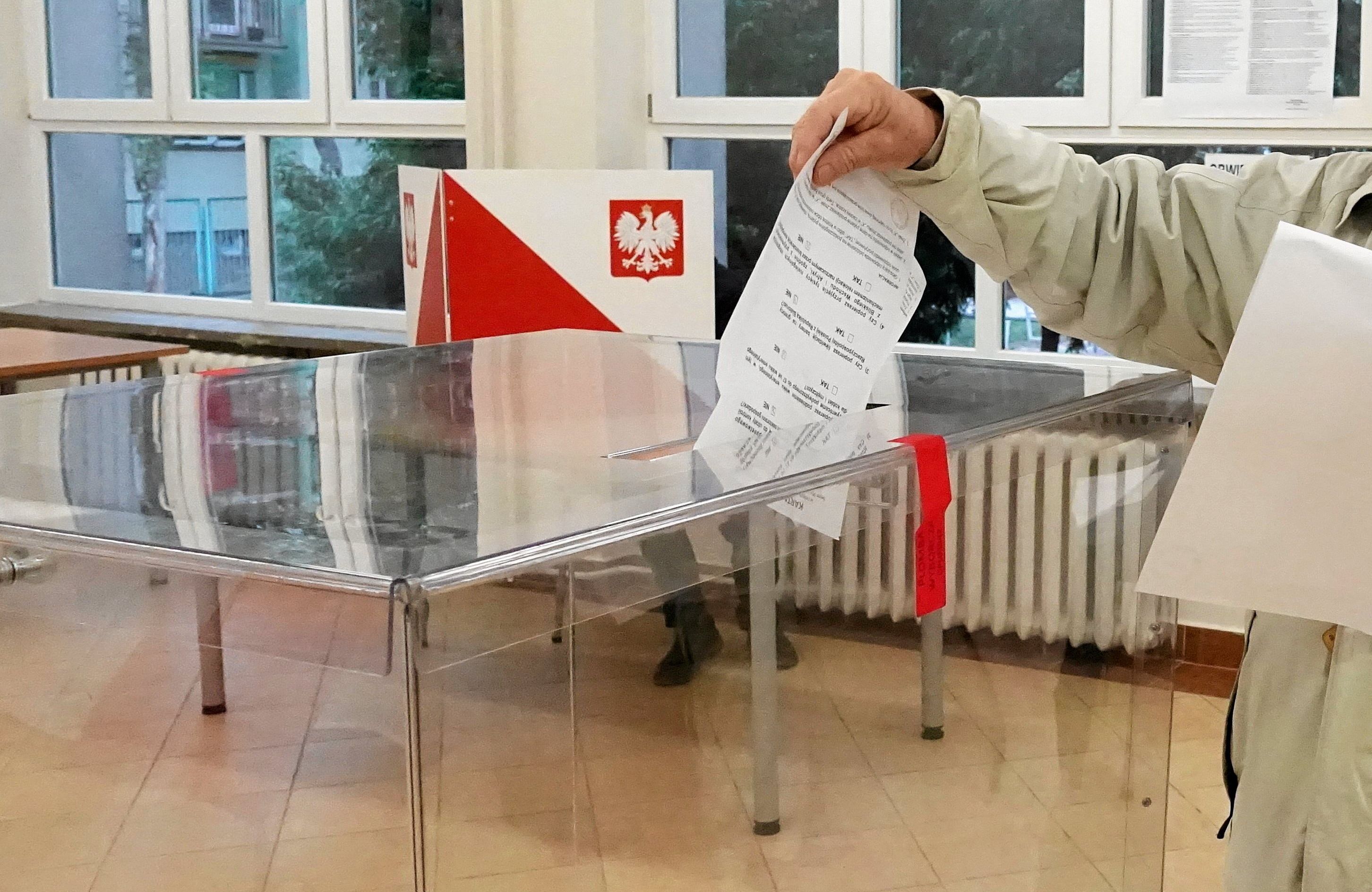 Ktoś wrzuca kartę wyborczą do urny