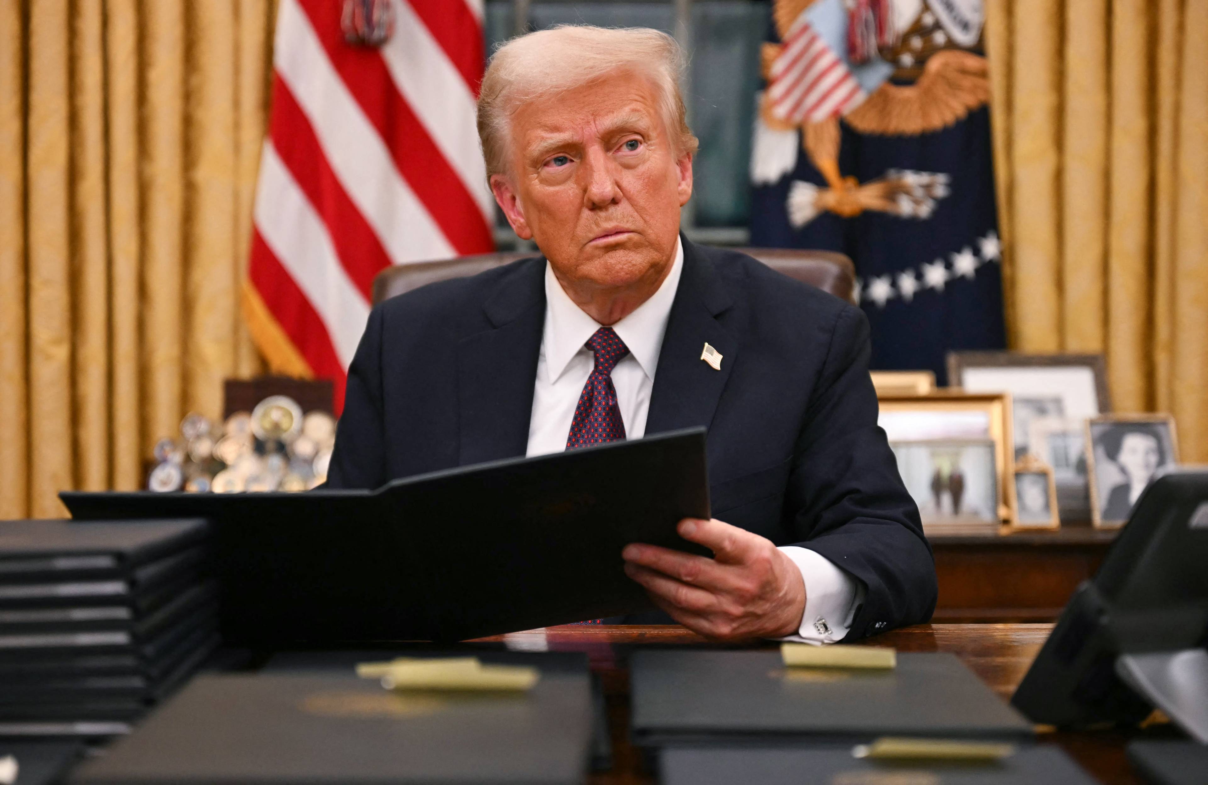 Donald Trump siedzi przy biurku