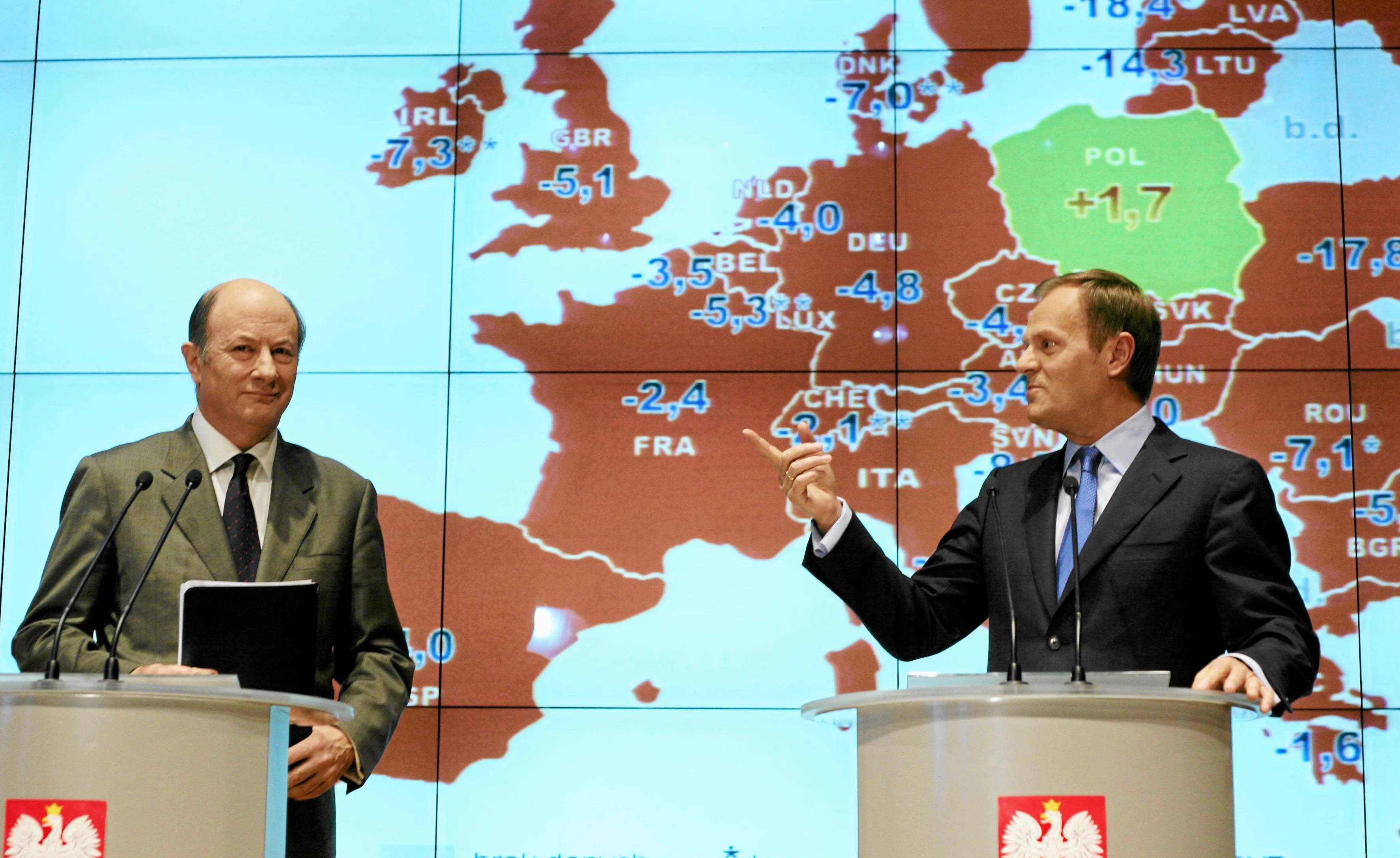Dwaj mężczyźni na tle mapy europy. To Jacek Rostowski i Donald Tusk. Na mapie Polska jest na zielono, a inne kraje na czerwono.