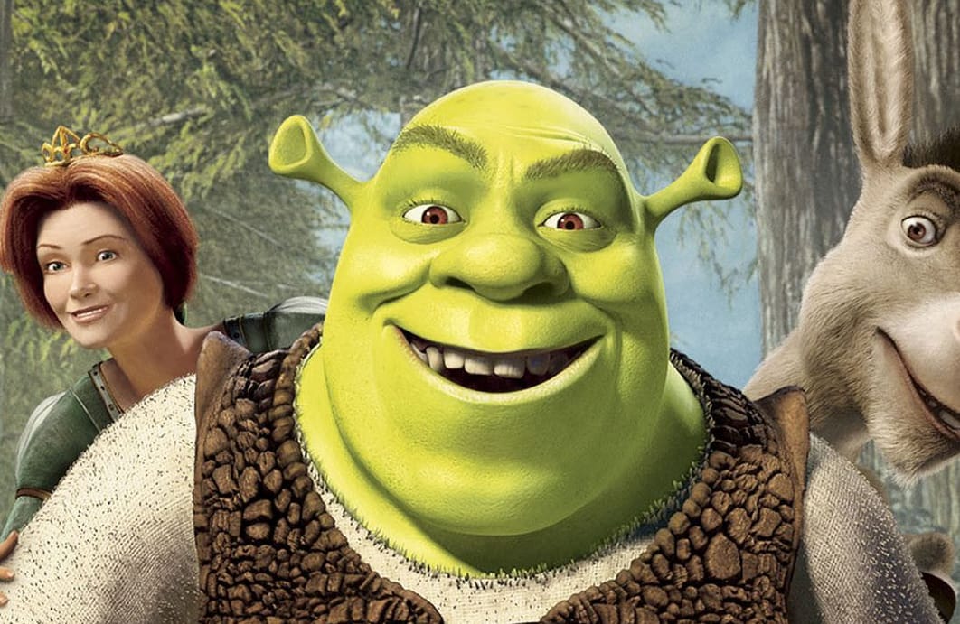 Kadr z filmu „Shrek”: uśmiechnięty Shrek, za jego plecami Osioł i Fiona