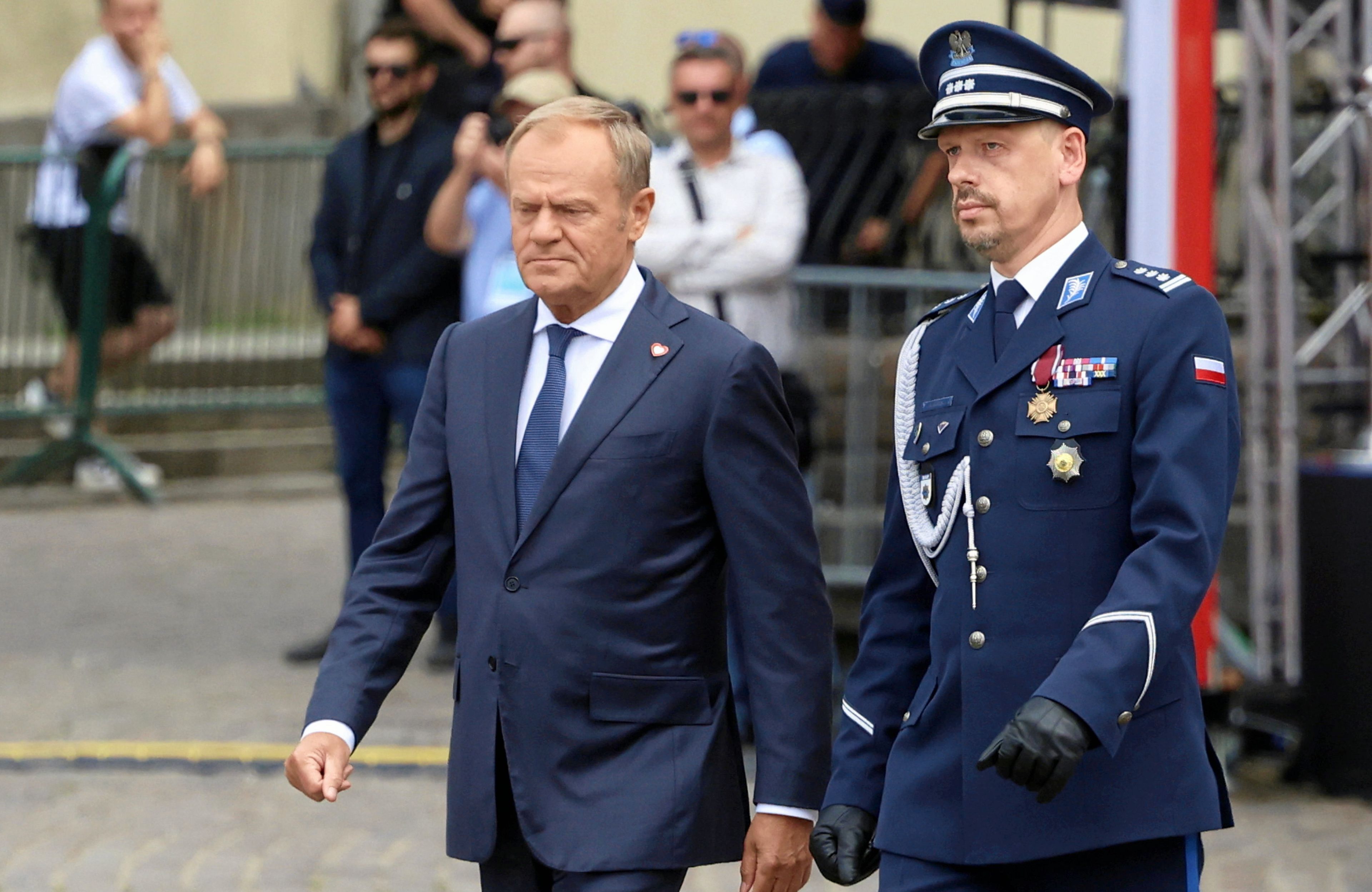 Mężczyzna w garniturze (Donald Tusk) i męzczyzna w policyjnym mundurze generalskim (komendant główny Policji Boroń)