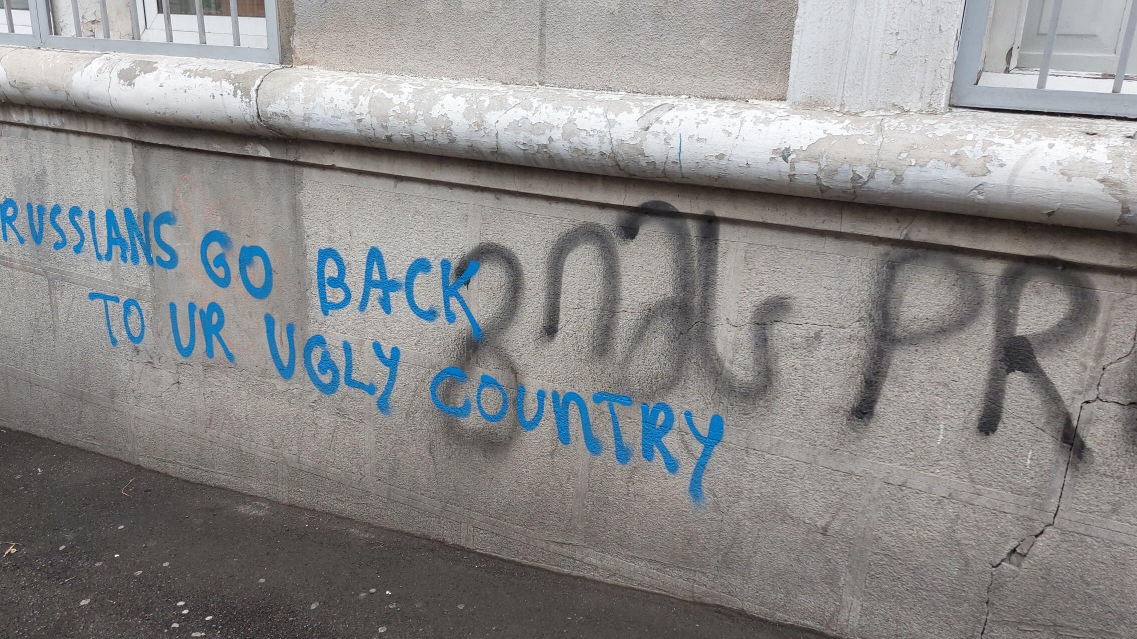 Napis na murze w języku angielskim: Rosjanie, wracajcie do swego brzydkiego kraju.